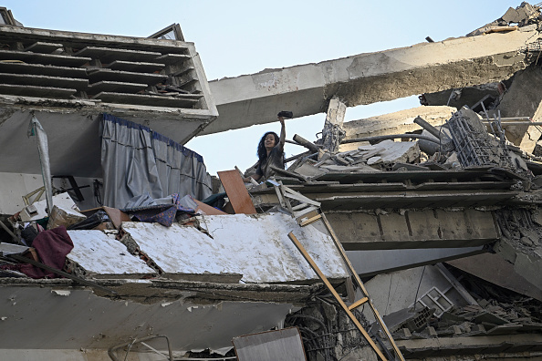 Una mujer hace señas para pedir ayuda desde la parte superior de un edificio de apartamentos dañado tras el terremoto ocurrido en Catia La Mar, estado La Guaira, a unos 30 kilómetros al noroeste de Caracas, el 25 de junio de 2026. Los dos sismos, los más fuertes registrados en Venezuela en más de un siglo, dejaron al menos 164 muertos y destruyeron numerosos edificios cerca de la capital, donde los habitantes continuaban buscando a sus familiares desaparecidos.