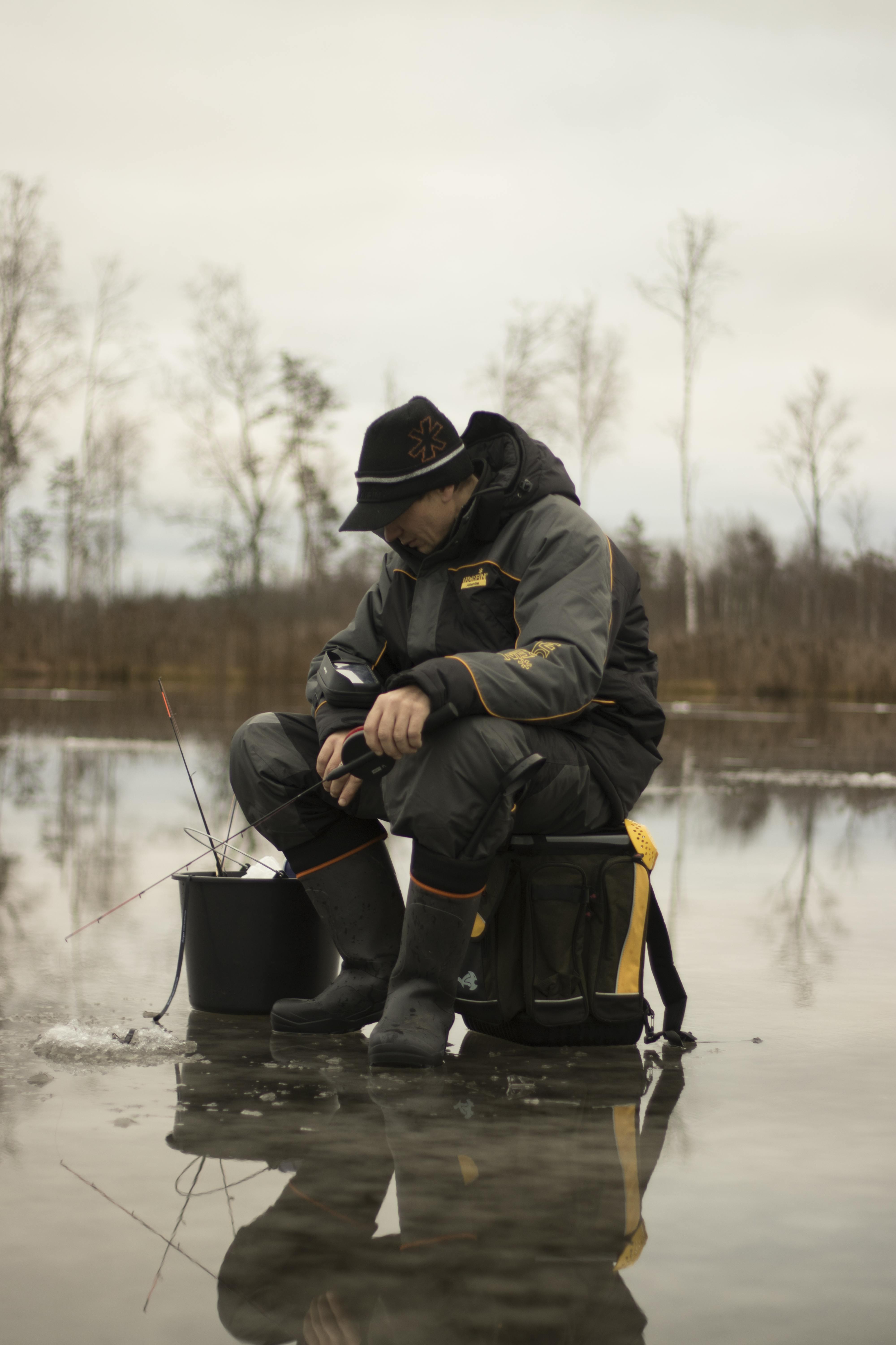 Un hombre pescando en el hielo en un lago helado | Fuente: Pexels