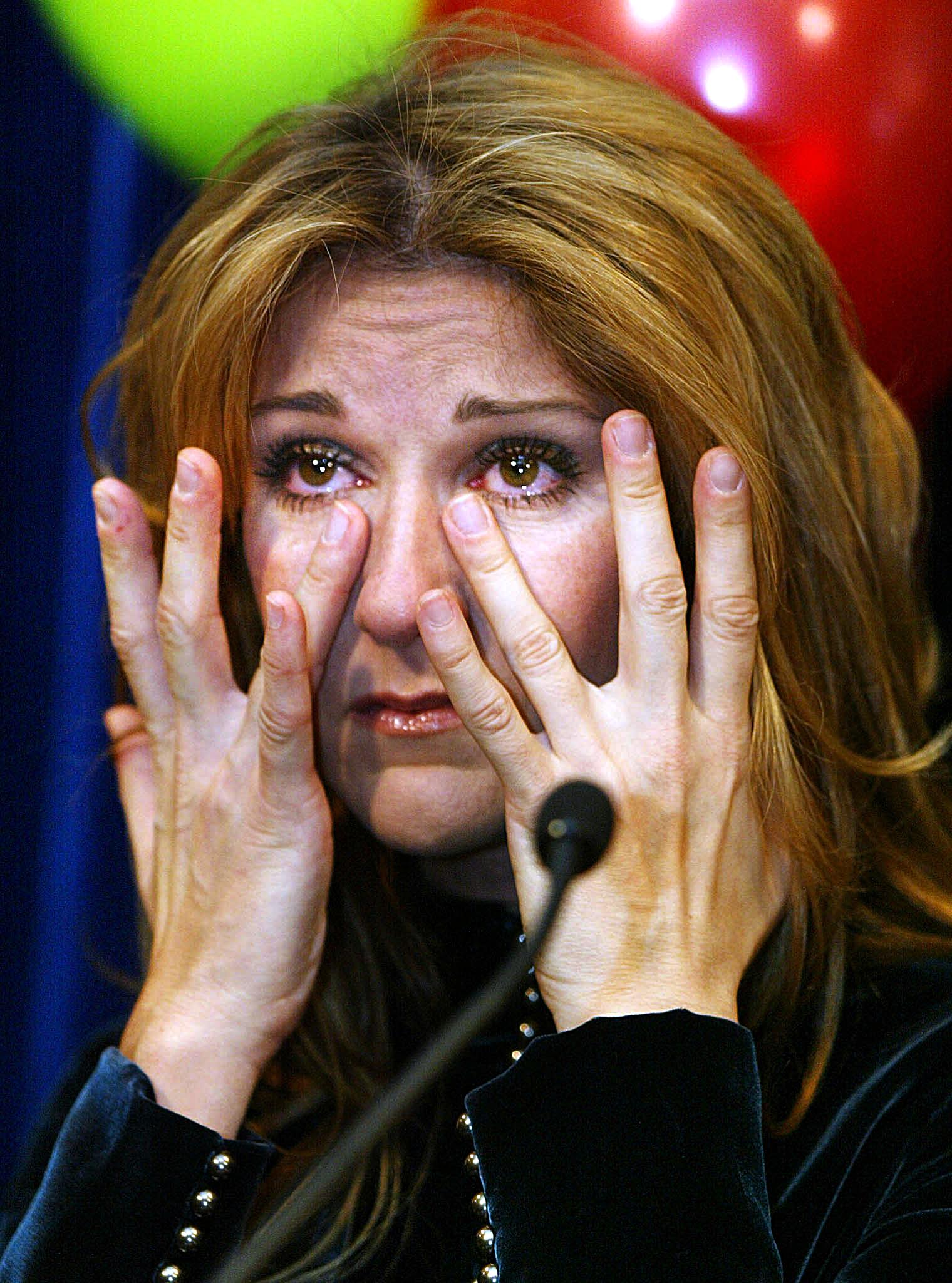 Céline Dion se seca las lágrimas mientras habla en el Hospital Infantil Sainte-Justine de Montreal, Canadá, el 18 de diciembre de 2002 | Fuente: Getty Images