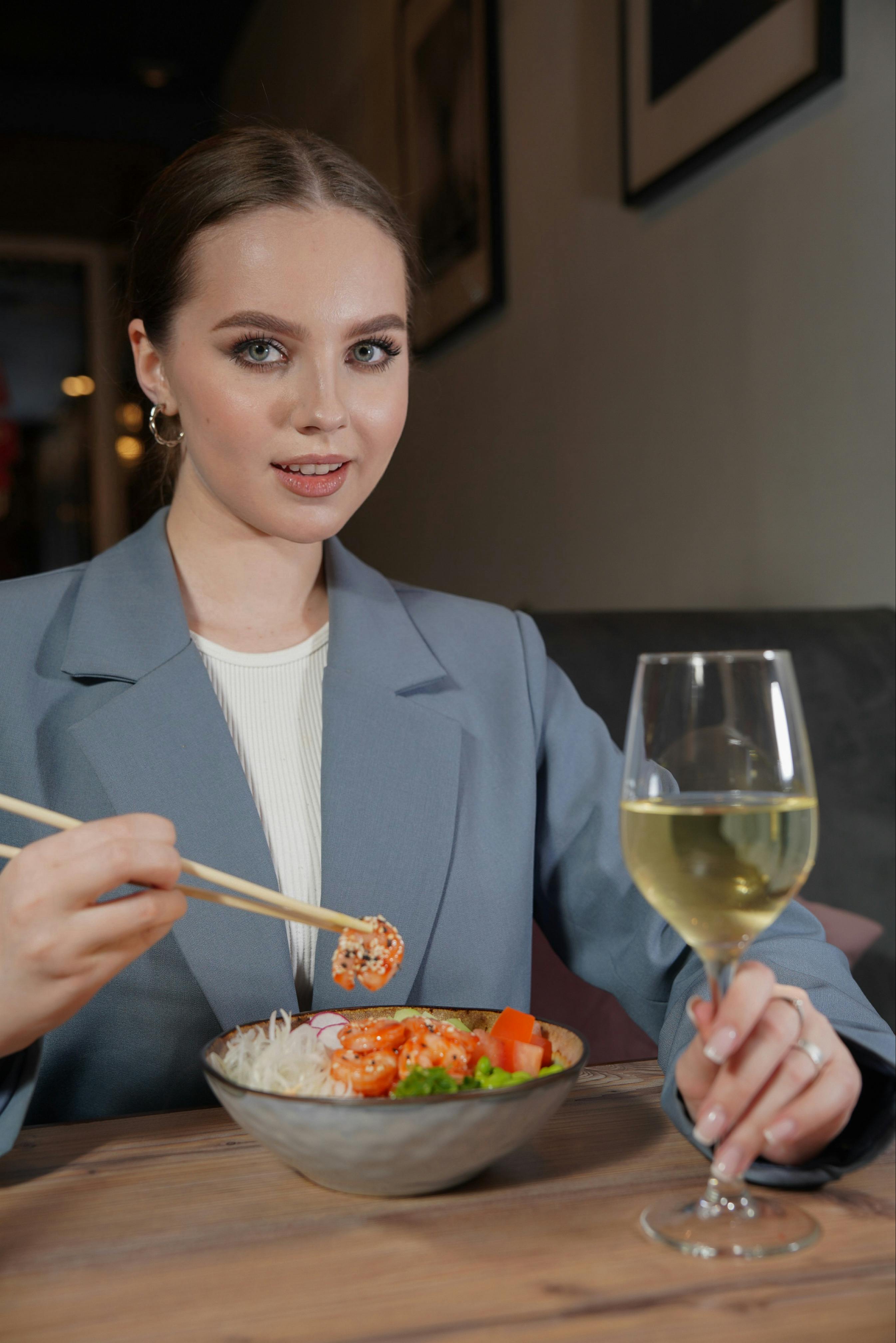 Una joven comiendo con palillos | Fuente: Pexels