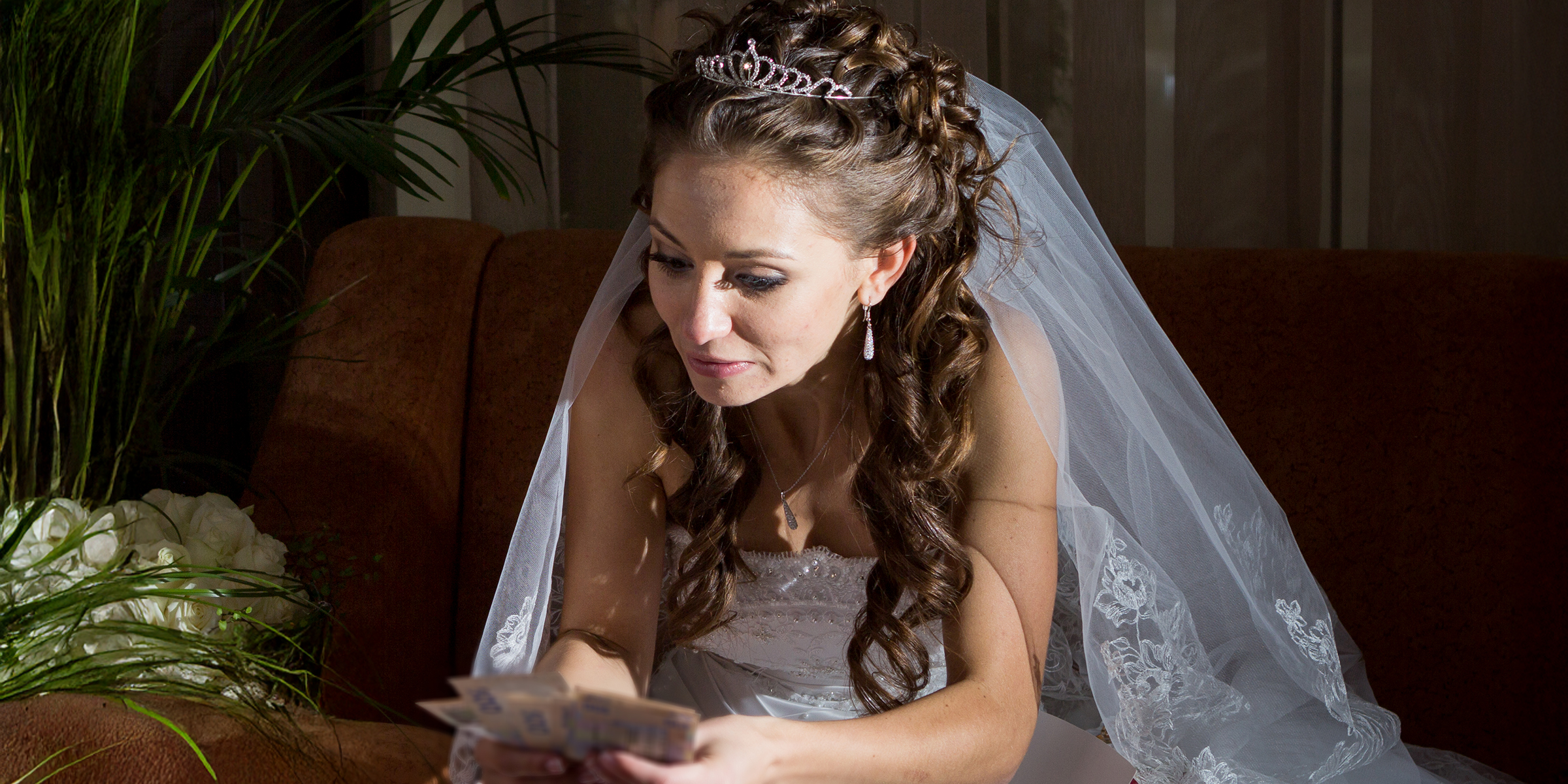 Una novia con dinero en la mano | Fuente: Shutterstock