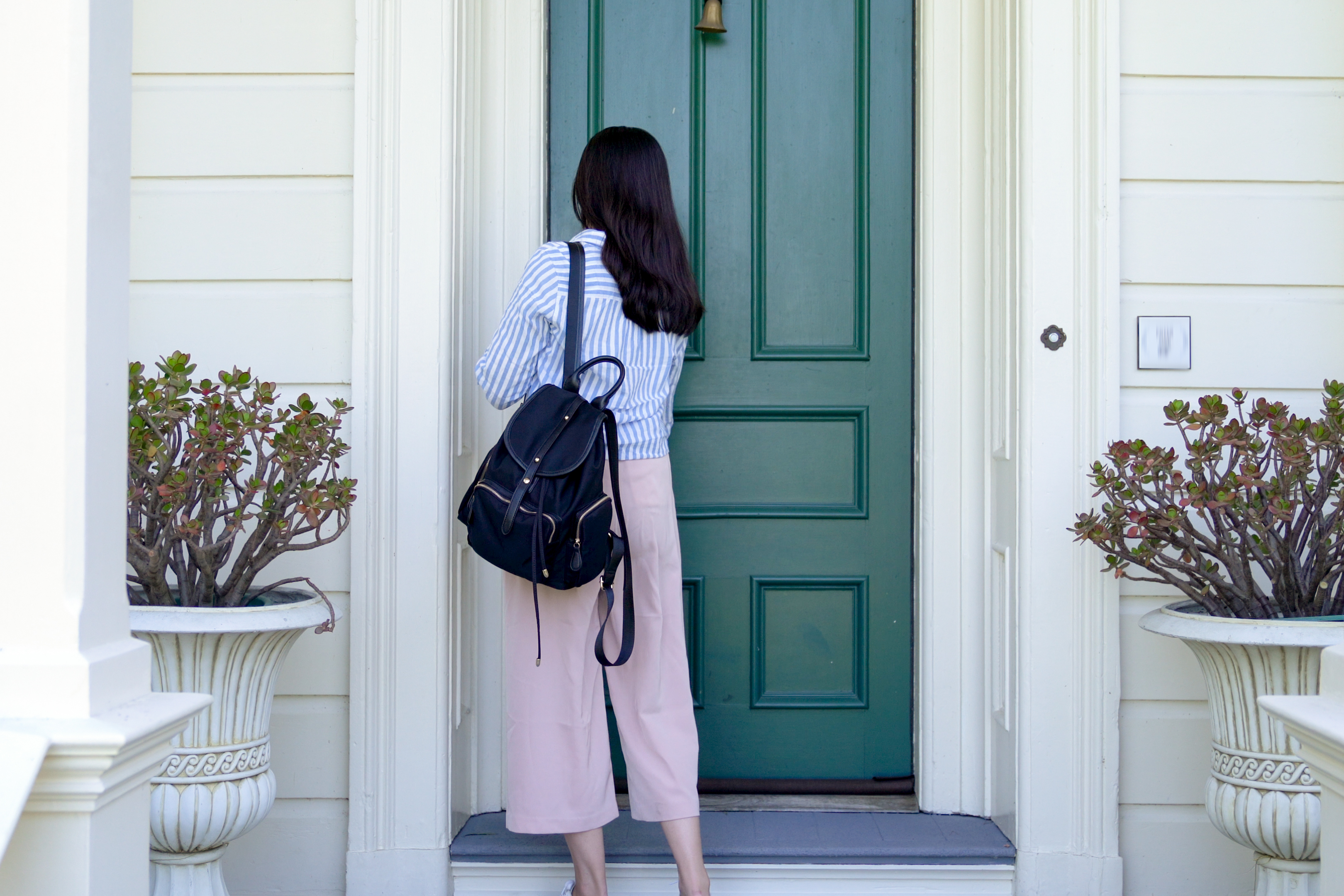 Estudiante universitario con mochila llama a la puerta. | Fuente: Shutterstock