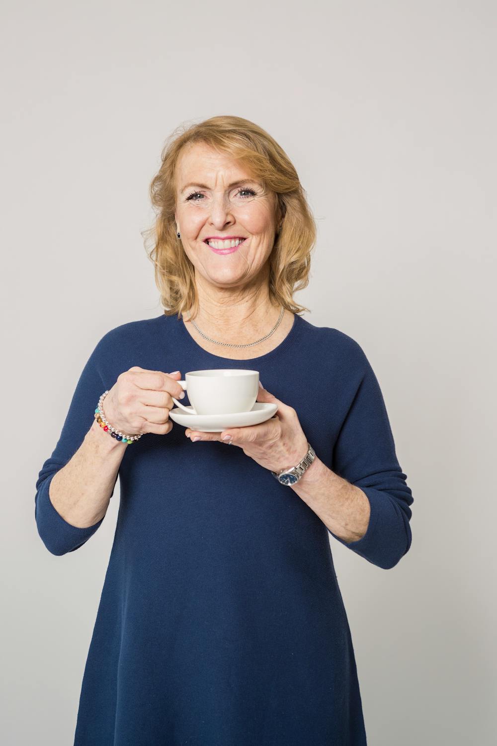 Una mujer sonriente con una taza de té | Fuente: Pexels