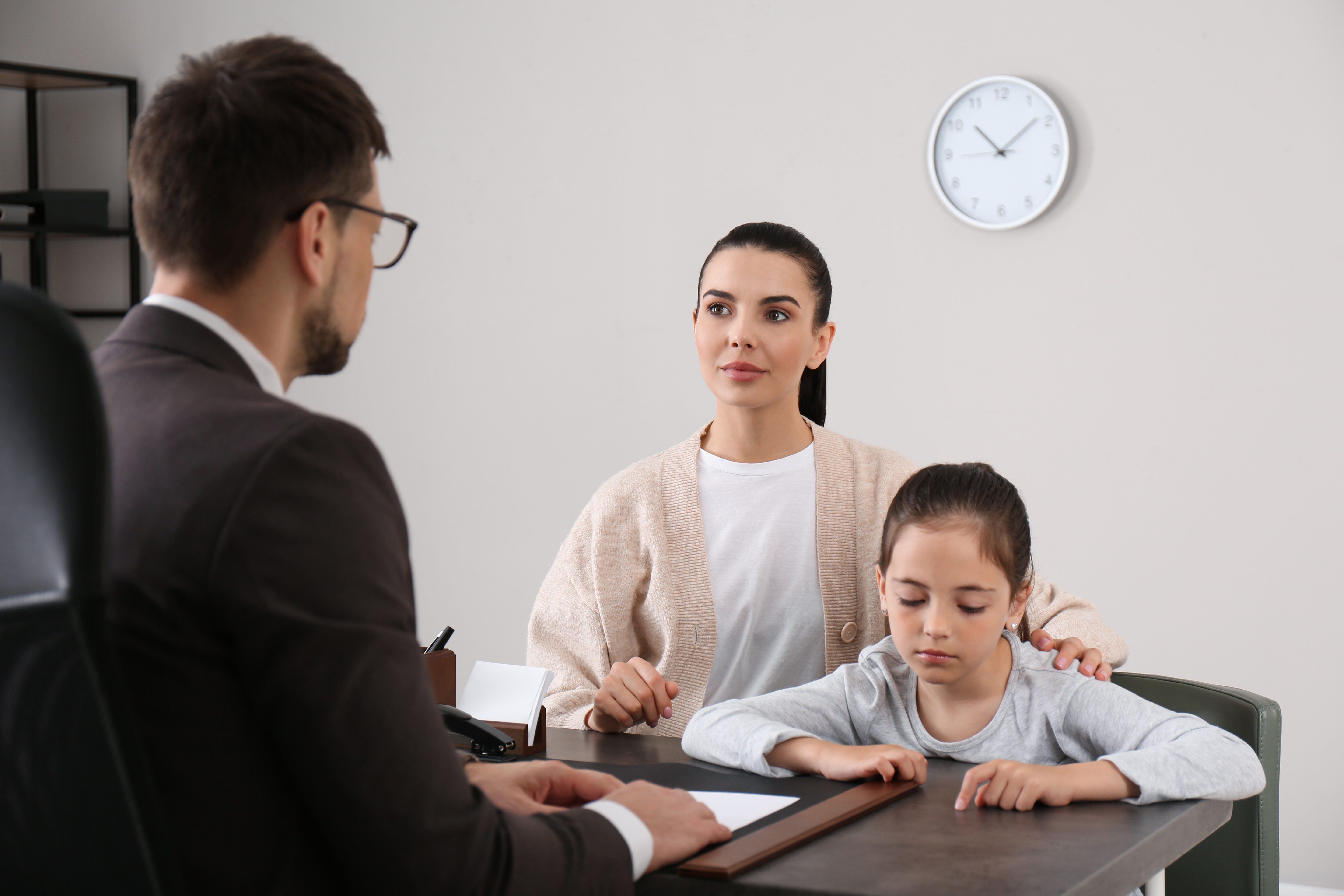 Una madre y su hija en una reunión con el director del colegio. | Foto: Shutterstock