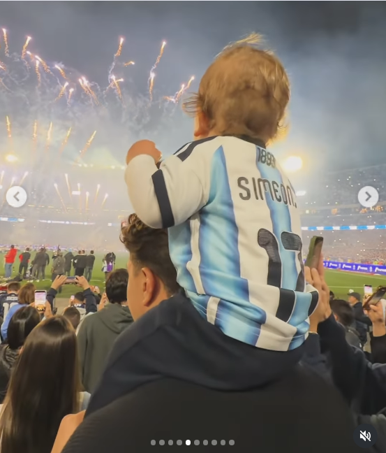 Ubicado en lo alto sobre los hombros de su papá, el pequeño Faustino levantó su brazo con entusiasmo mientras contemplaba las bengalas y luces en el cielo del Monumental. La postal resalta su camiseta de la Selección con el número 17 y la estampa de Simeone en la espalda durante el fin de fiesta. | Fuente: Instagram/evabargiela
