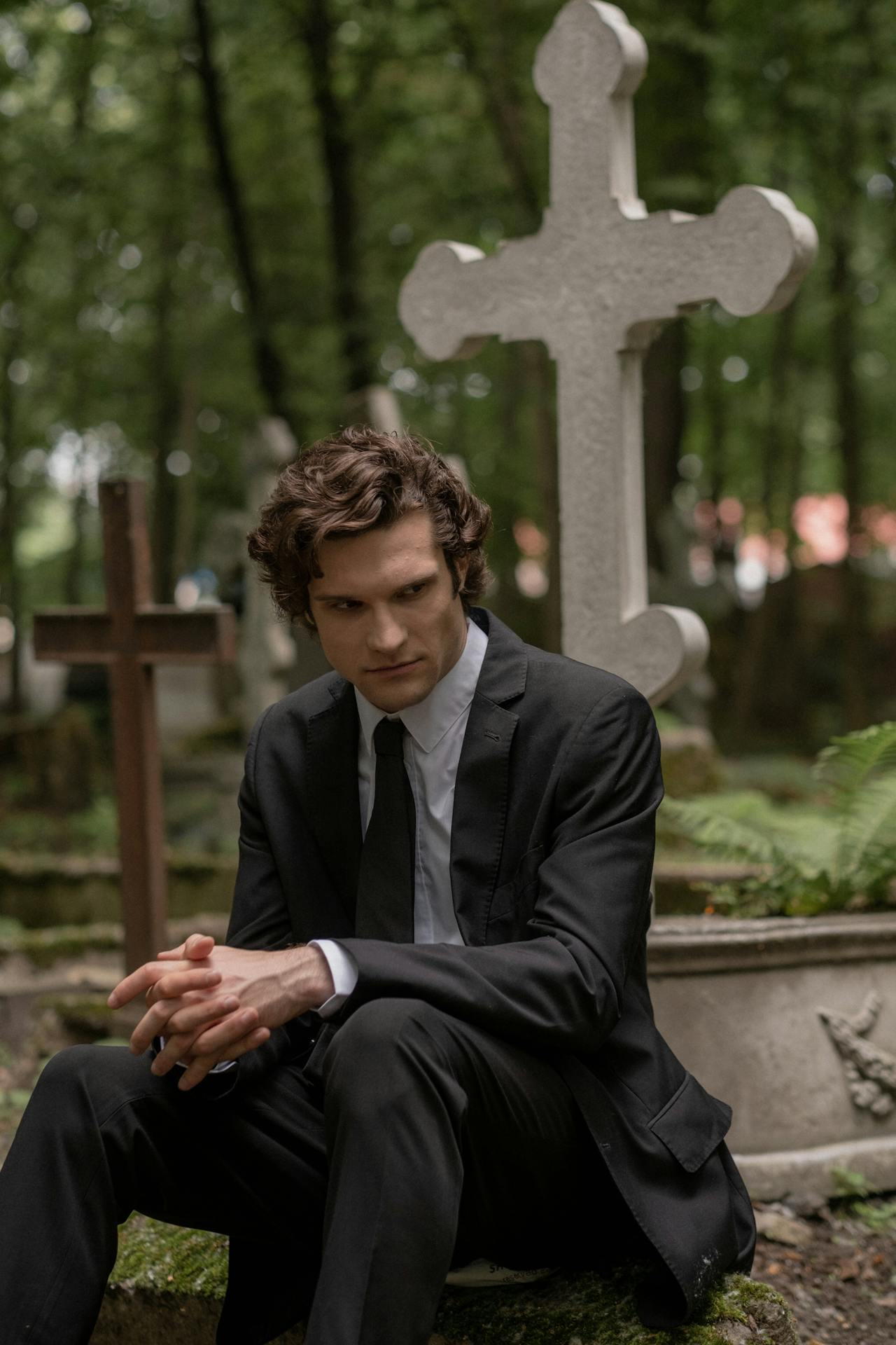 Un uomo seduto in un cimitero | Fonte: Pexels