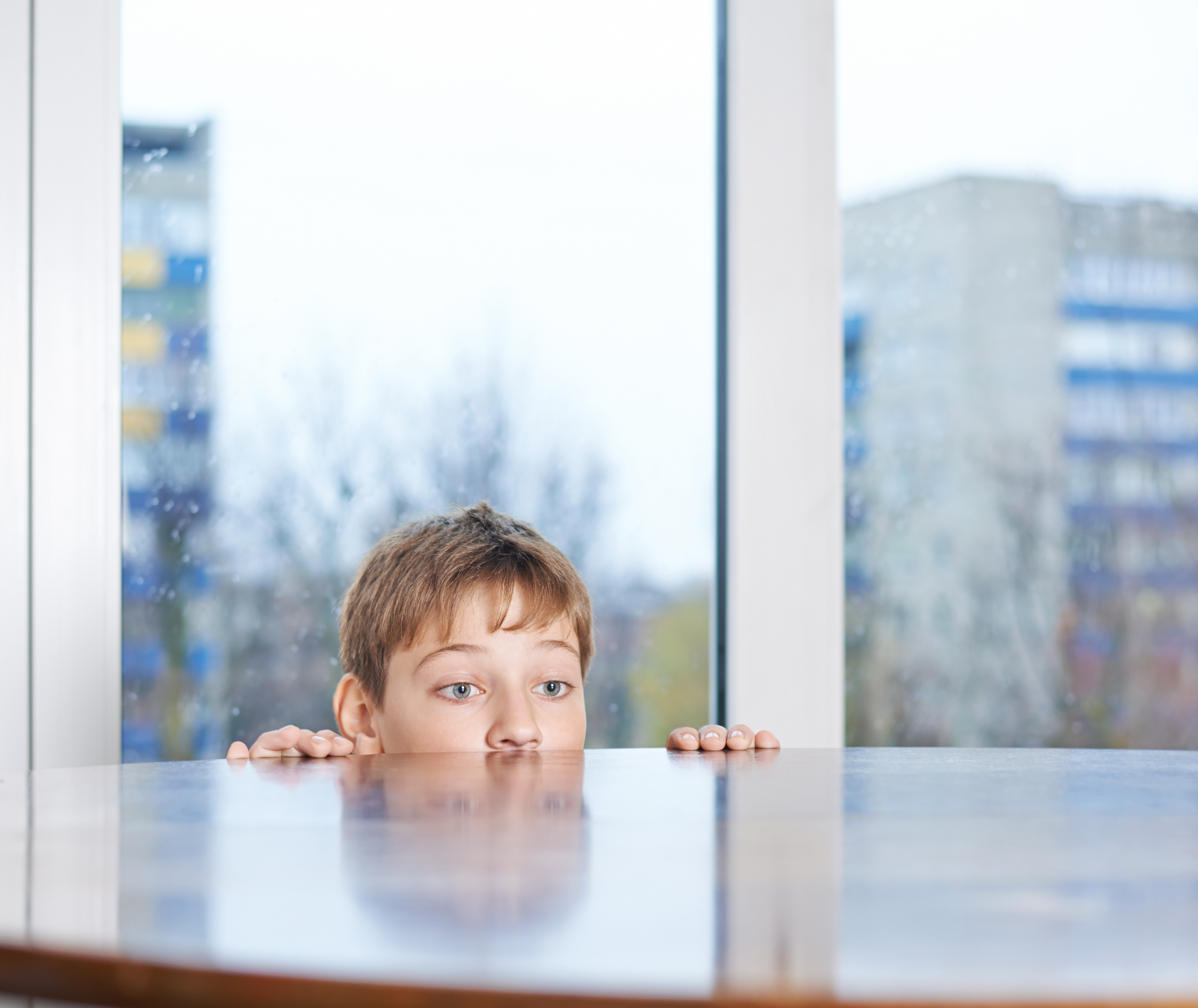 Niño asomándose sobre la mesa | Foto: Shutterstock