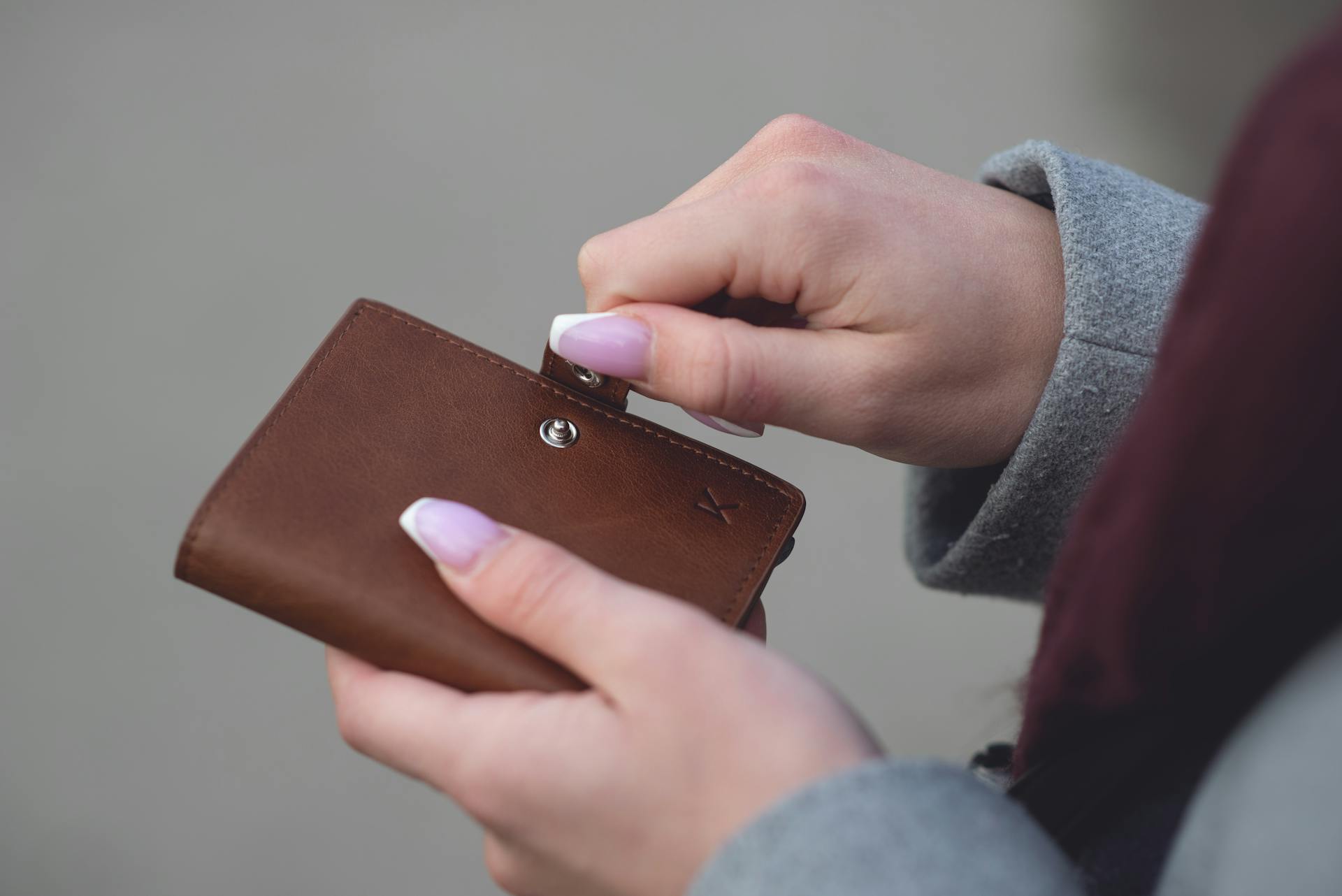 Una mujer sujetando su cartera | Fuente: Pexels