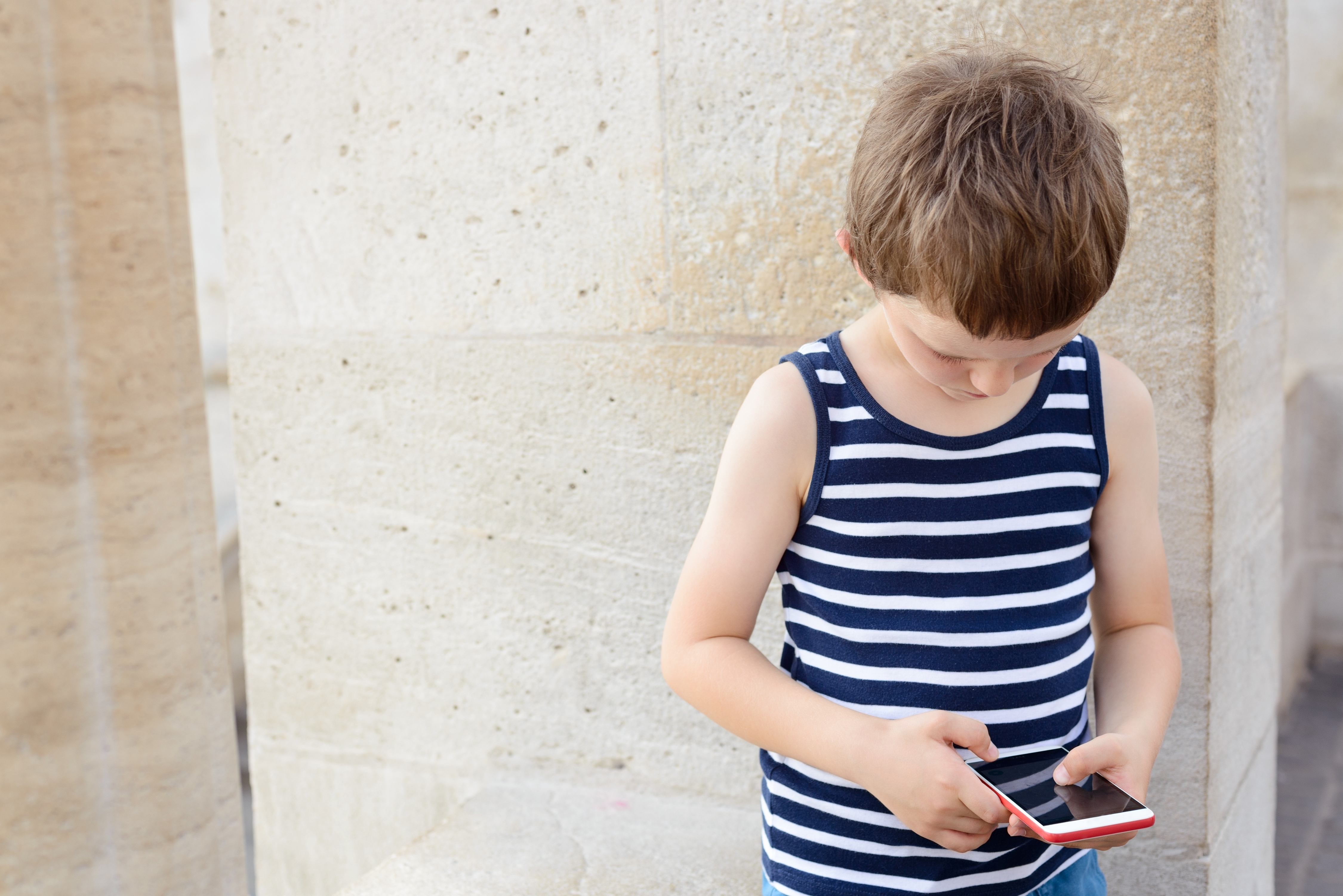 Niño con un teléfono | Fuente: Shutterstock.com