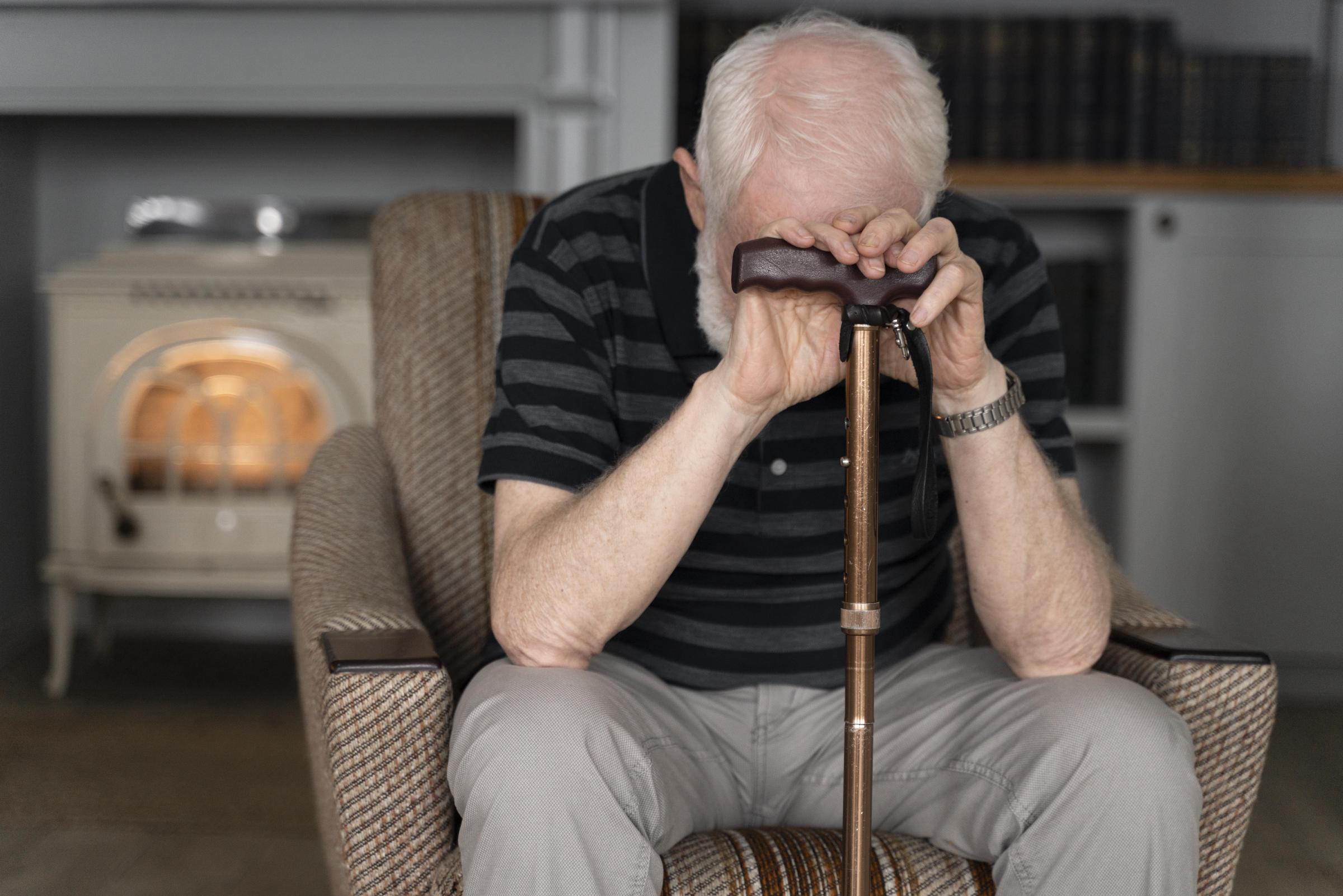 Un hombre mayor triste apoyado en su bastón | Fuente: Freepik