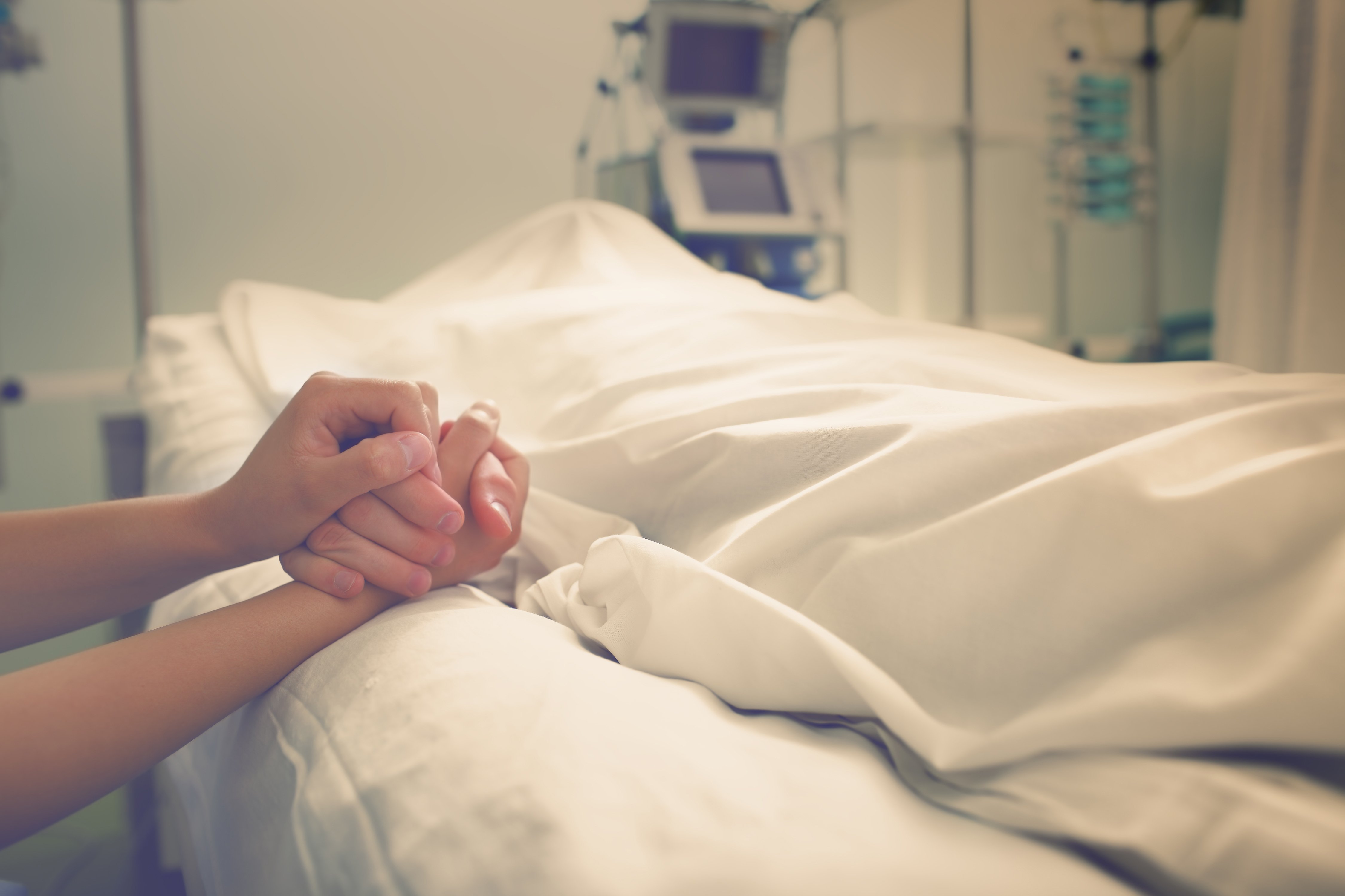 Mano de paciente hospitalario entrelazada con las de acompañante. | Foto: Shutterstock