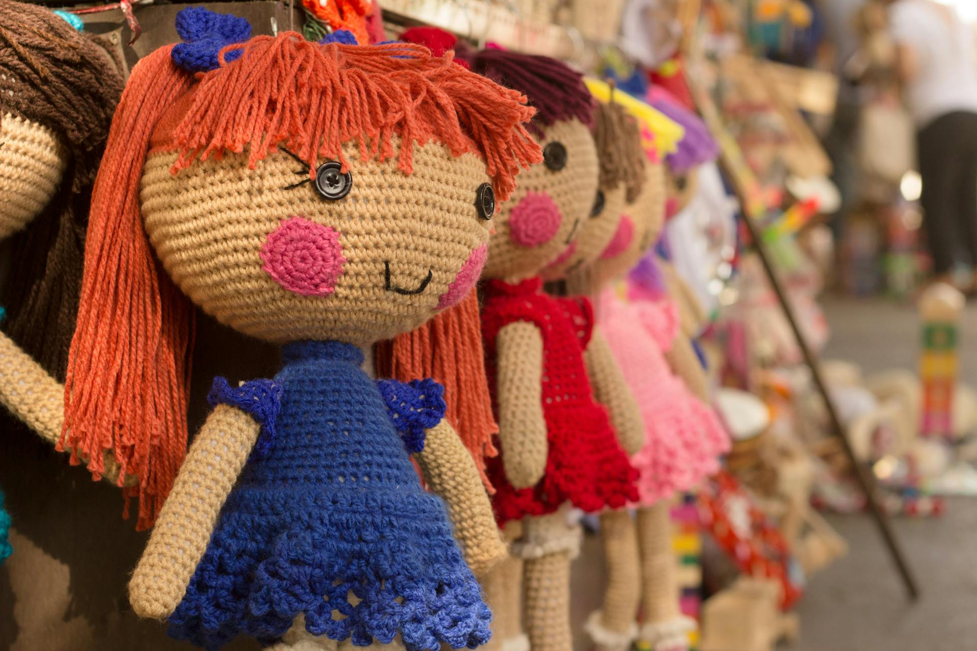 Muñecas de crochet colgadas en una tienda | Foto: Pexels
