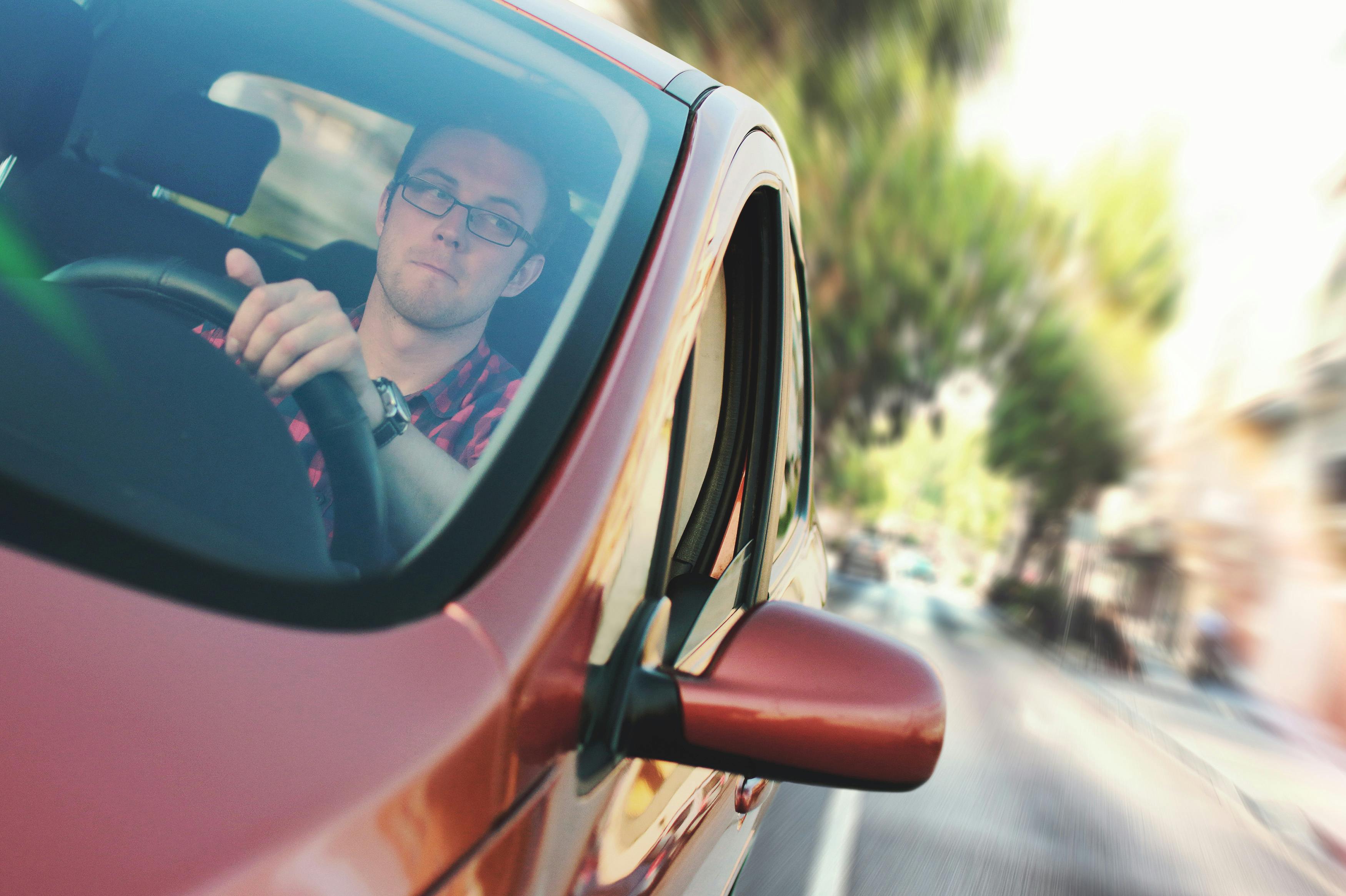 Un hombre conduciendo un Automóvil rojo | Foto: Pexels