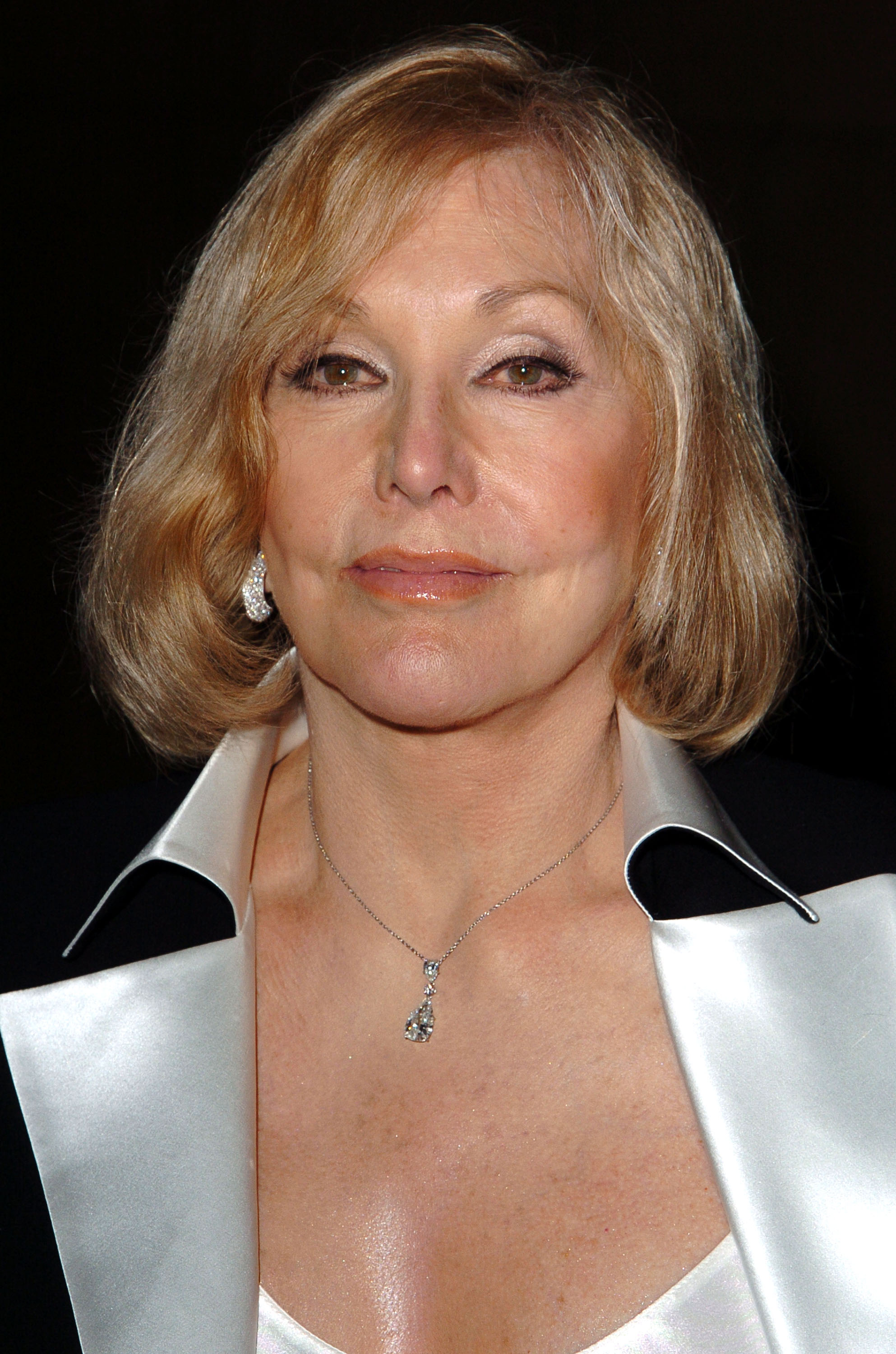 Kim Novak asiste a una proyección de "Vertigo" en el Egyptian Theatre de Hollywood, con un conjunto de satén blanco con cuello negro a contraste y un collar con colgante. | Fuente: Getty Images