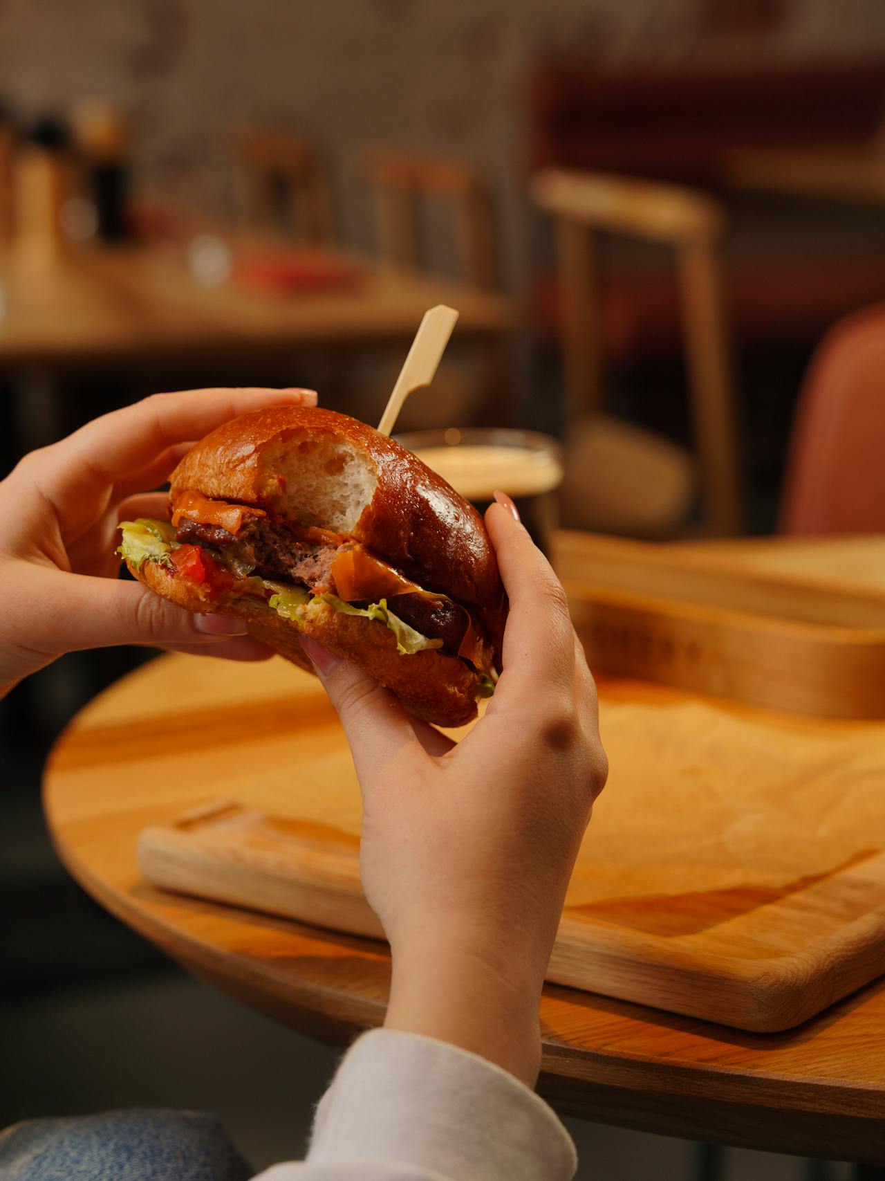 Una mujer comiendo una hamburguesa | Fuente: Pexels