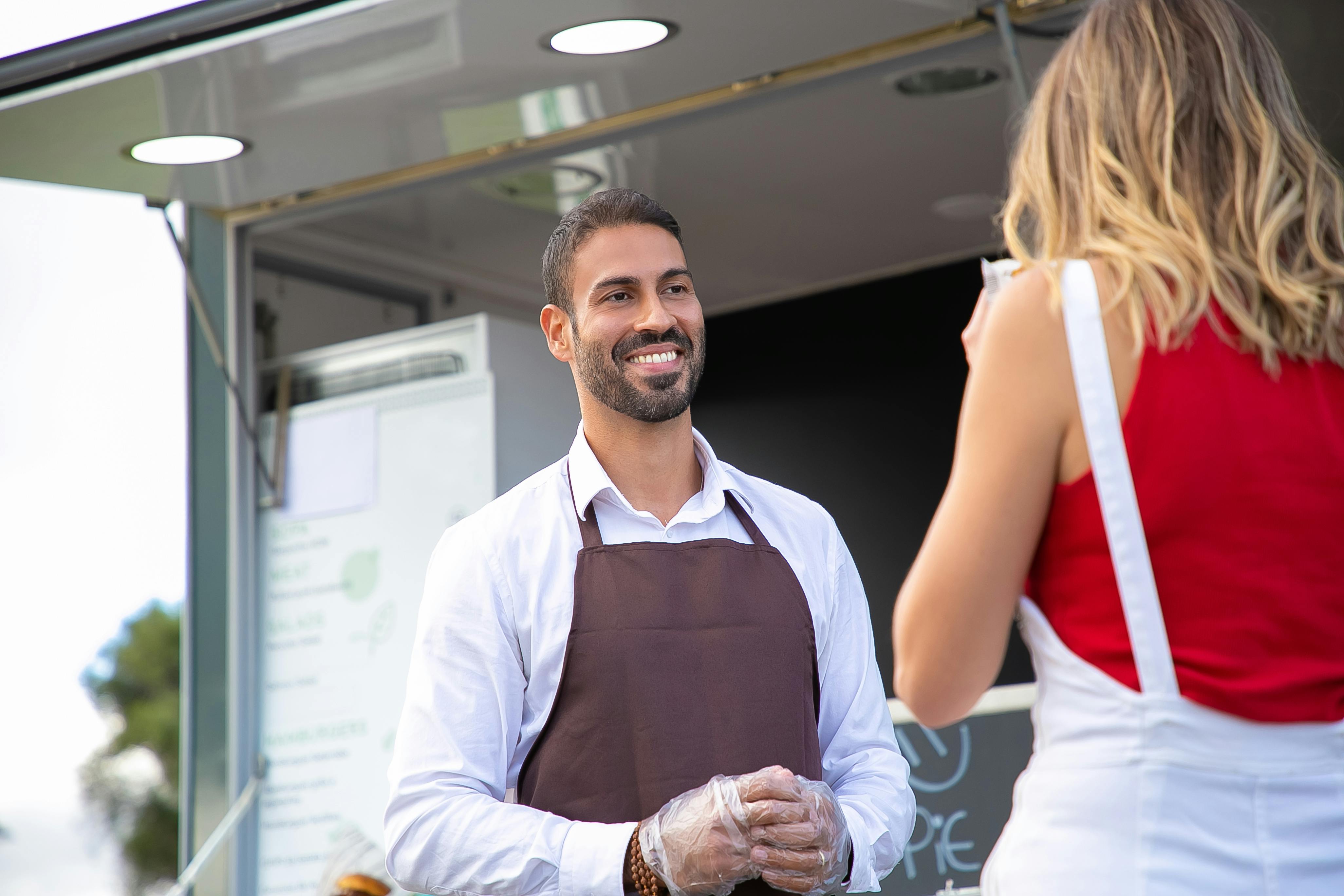 Mesero hablando con una cliente | Foto: Pexels