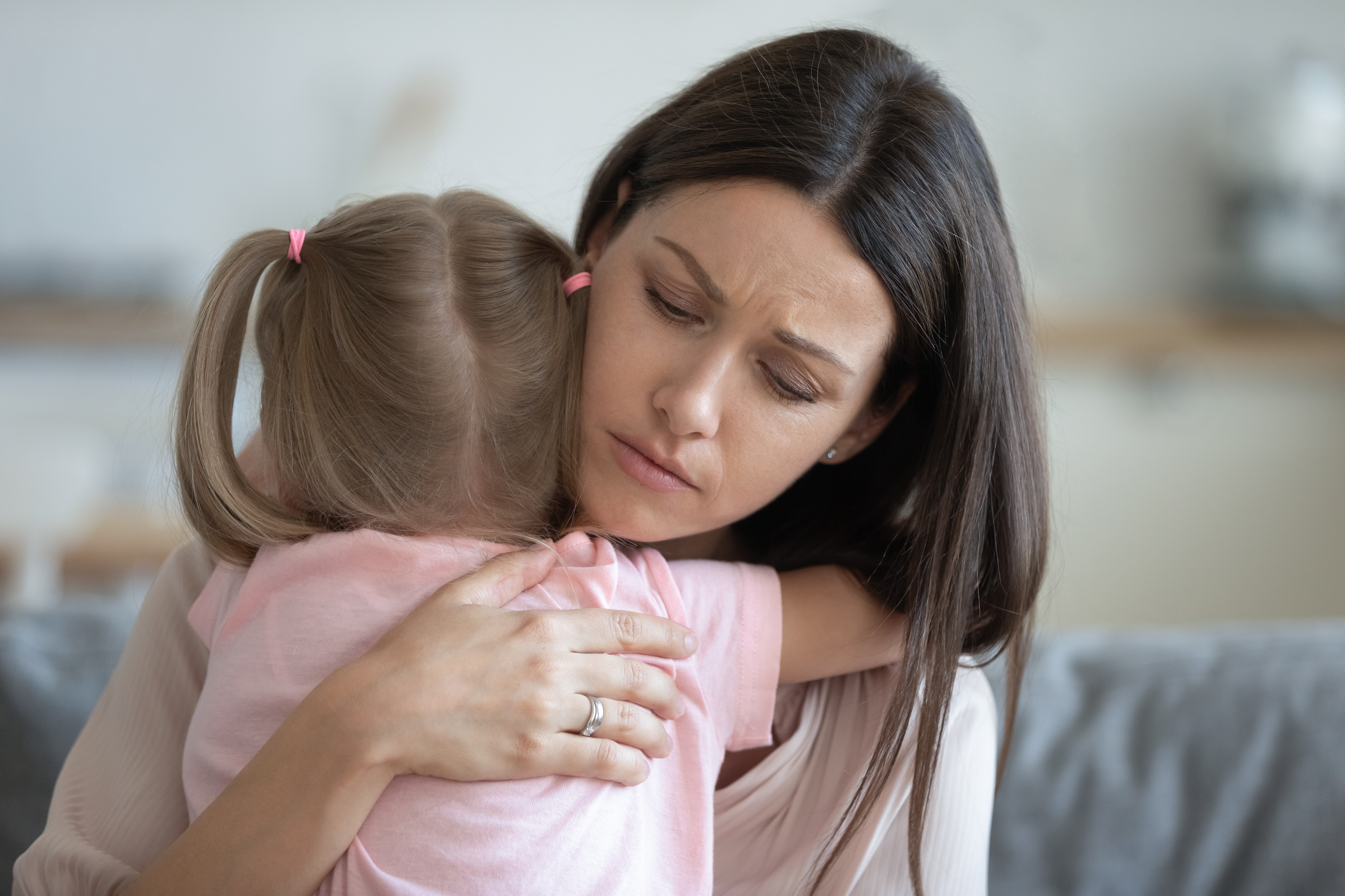 Joven madre preocupada sujetando a su hija | Foto: Shutterstock
