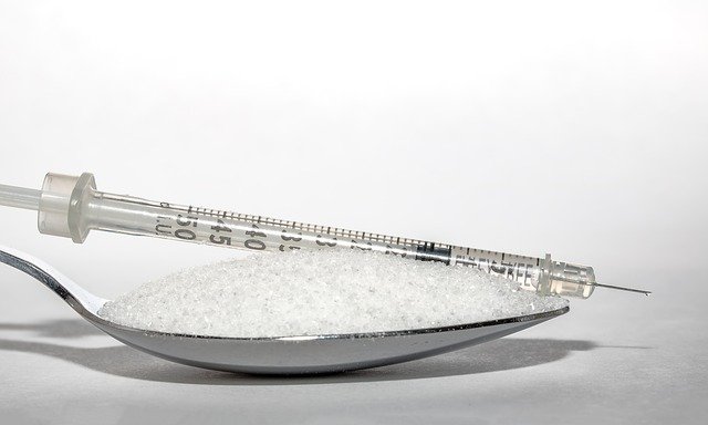 Jeringa con insulina sobre una cuchara con azúcar. Fuente: Pixabay