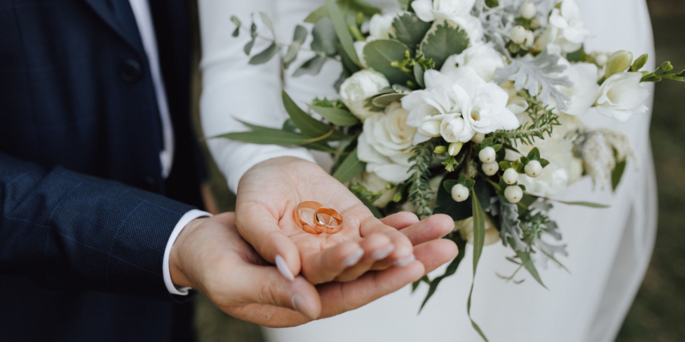 Una novia y un novio sosteniendo sus anillos de boda | Fuente: Freepik