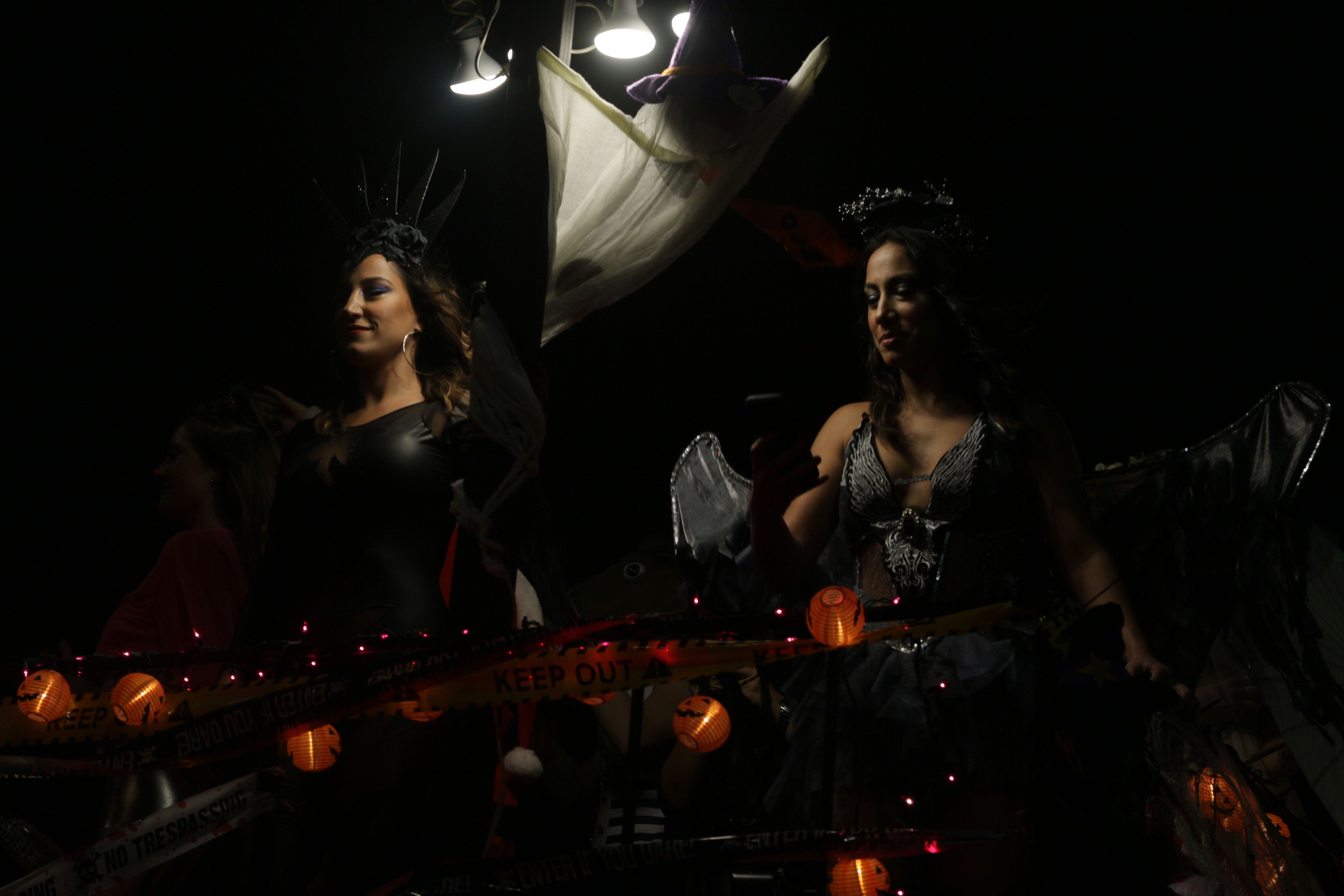 Unas chicas con disfraces de Halloween participan en un animado desfile nocturno, en el que se pueden ver decoraciones festivas | Fuente: Pexels