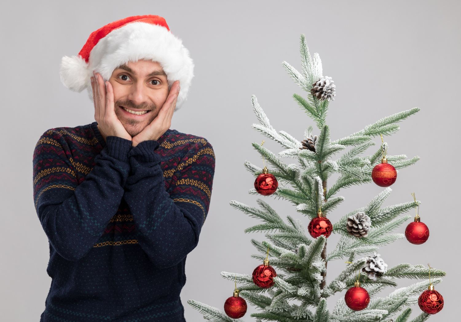 Un hombre emocionado cerca de un árbol de Navidad | Fuente: Freepik