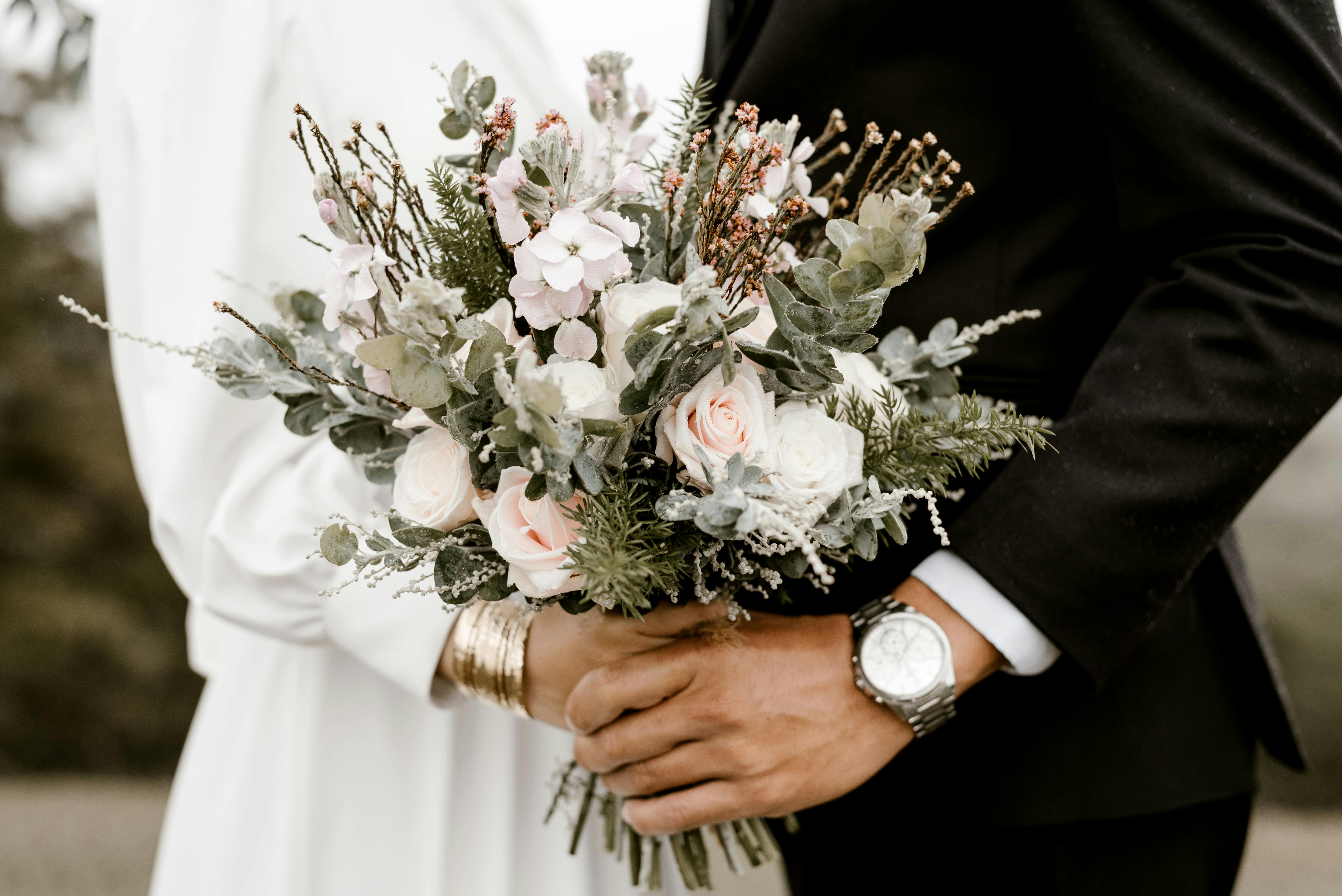 El novio y la novia bailan sujetando un ramo de novia | Fuente: Pexels