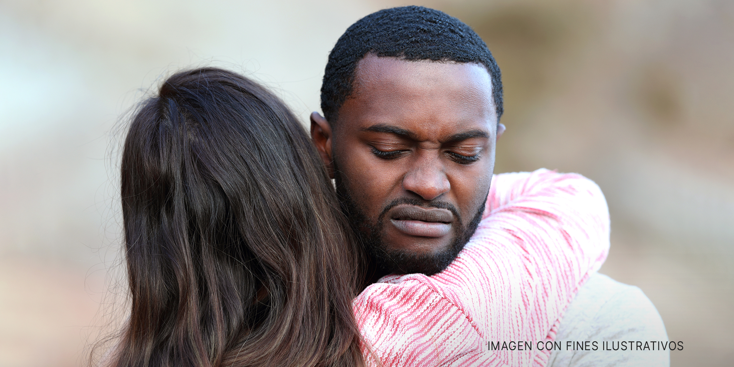 Un hombre con cara de asco mientras abraza a una mujer | Foto: Getty Images
