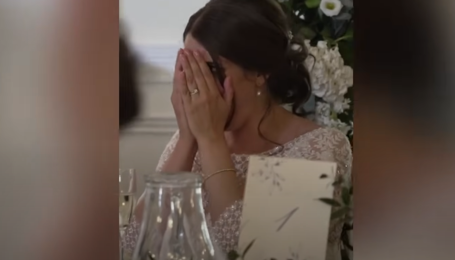 La recién casada Katie se tapa la cara mientras Ian Young pronuncia su discurso | Fuente: YouTube / Daily Record