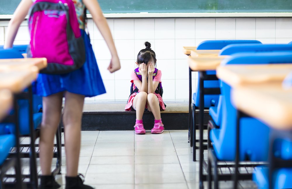 Niña intimidada en el aula escolar. | Foto: Shutterstock
