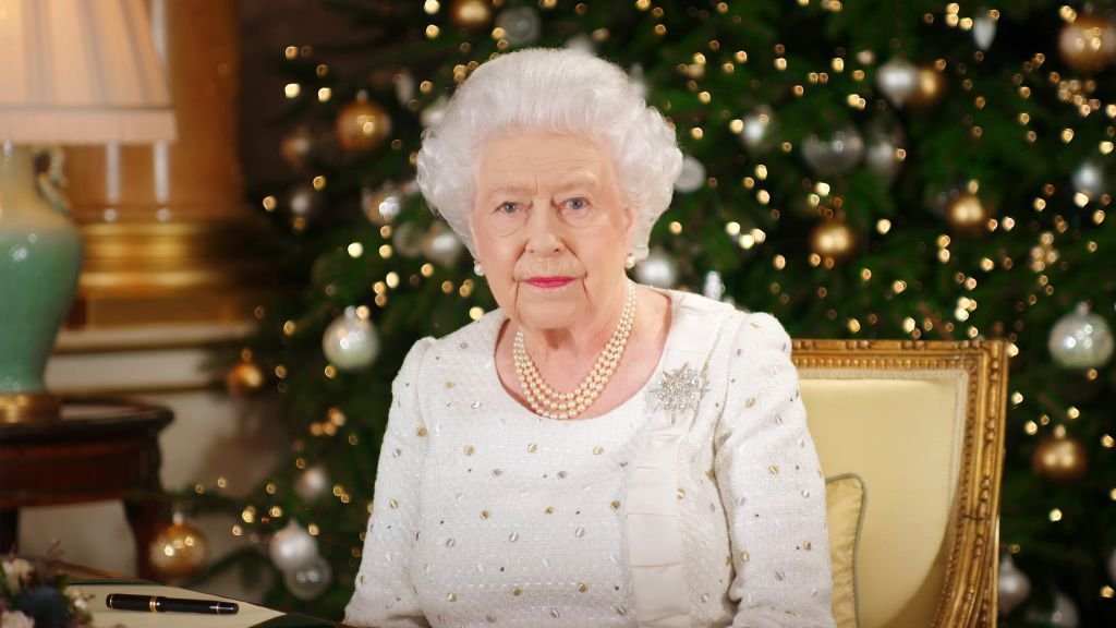 La Reina Isabel II en un escritorio en el Palacio de Buckingham, mientras graba su transmisión del día de Navidad en Londres. | Foto: Getty Images