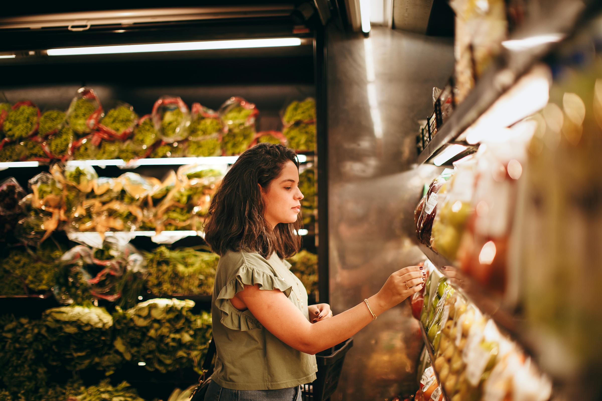 Una mujer en la sección de frutas y verduras de un supermercado | Fuente: Pexels