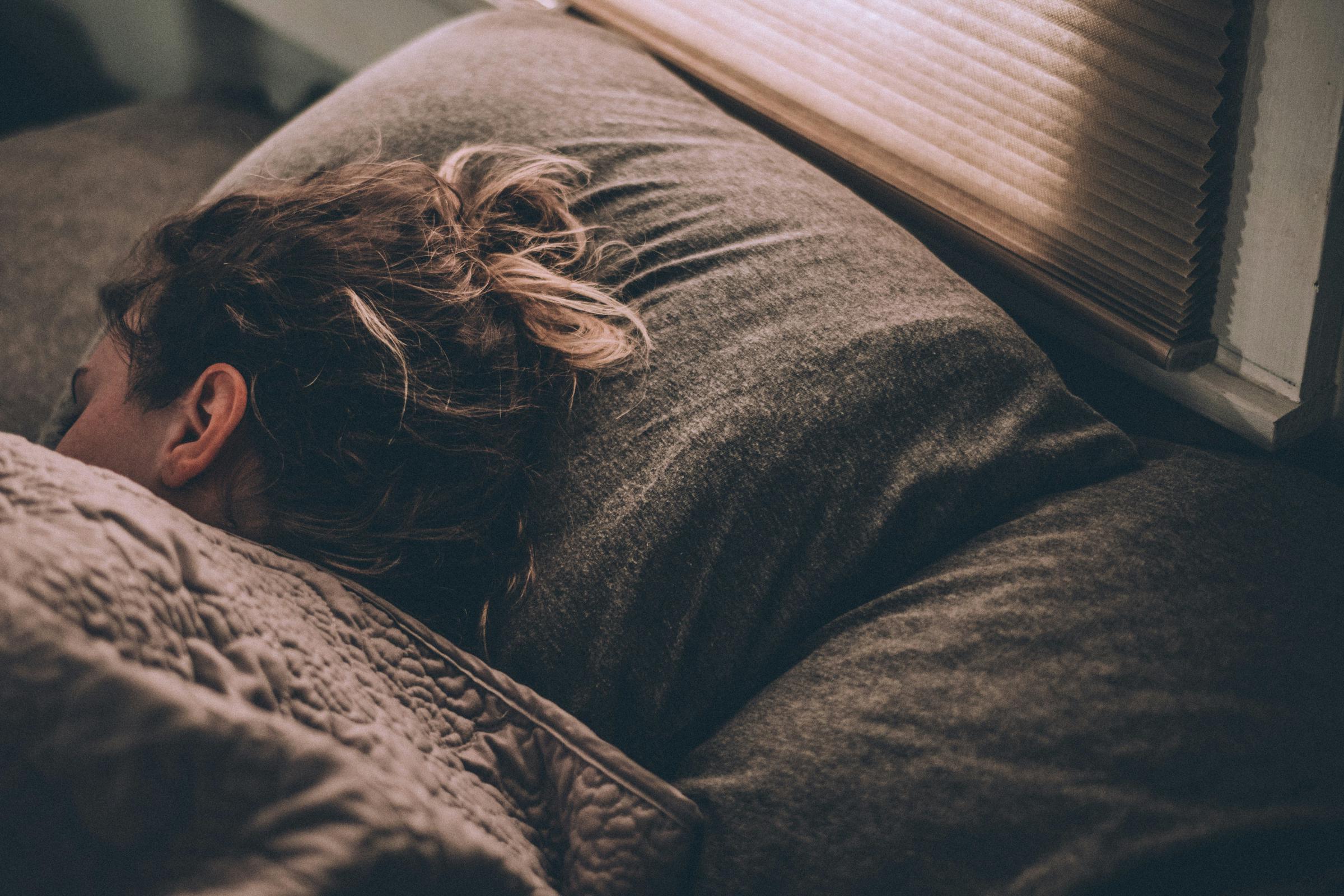 Una mujer durmiendo en una cómoda cama | Fuente: Unsplash