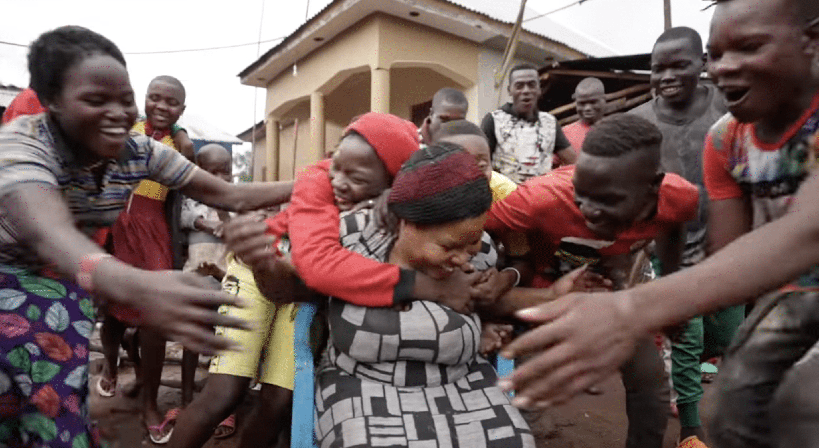 La enorme prole de Nabatanzi la envuelve en un abrazo amoroso. | Foto: YouTube.com/Connect With Uganda