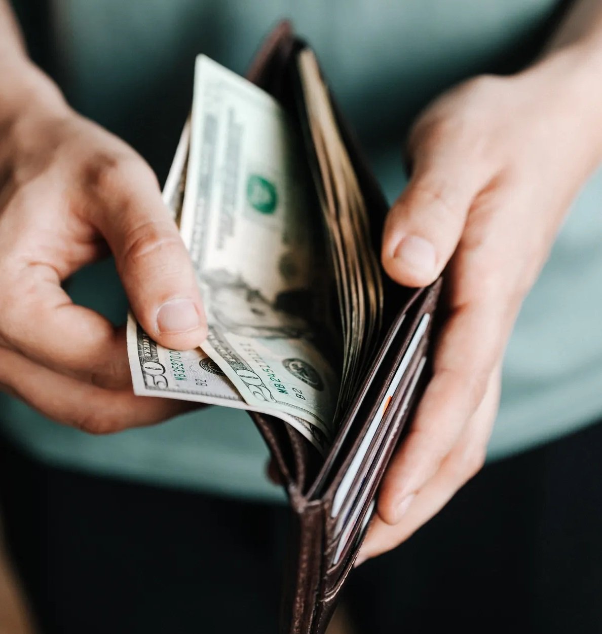 Persona contando el dinero dentro de una billetera. | Foto: Pexels
