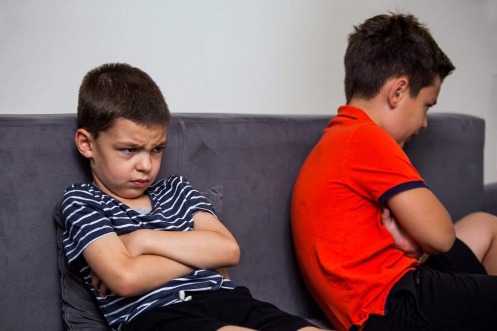 Niño enojado ignorando a su hermano después de una pelea. | Fuente: Shutterstock.