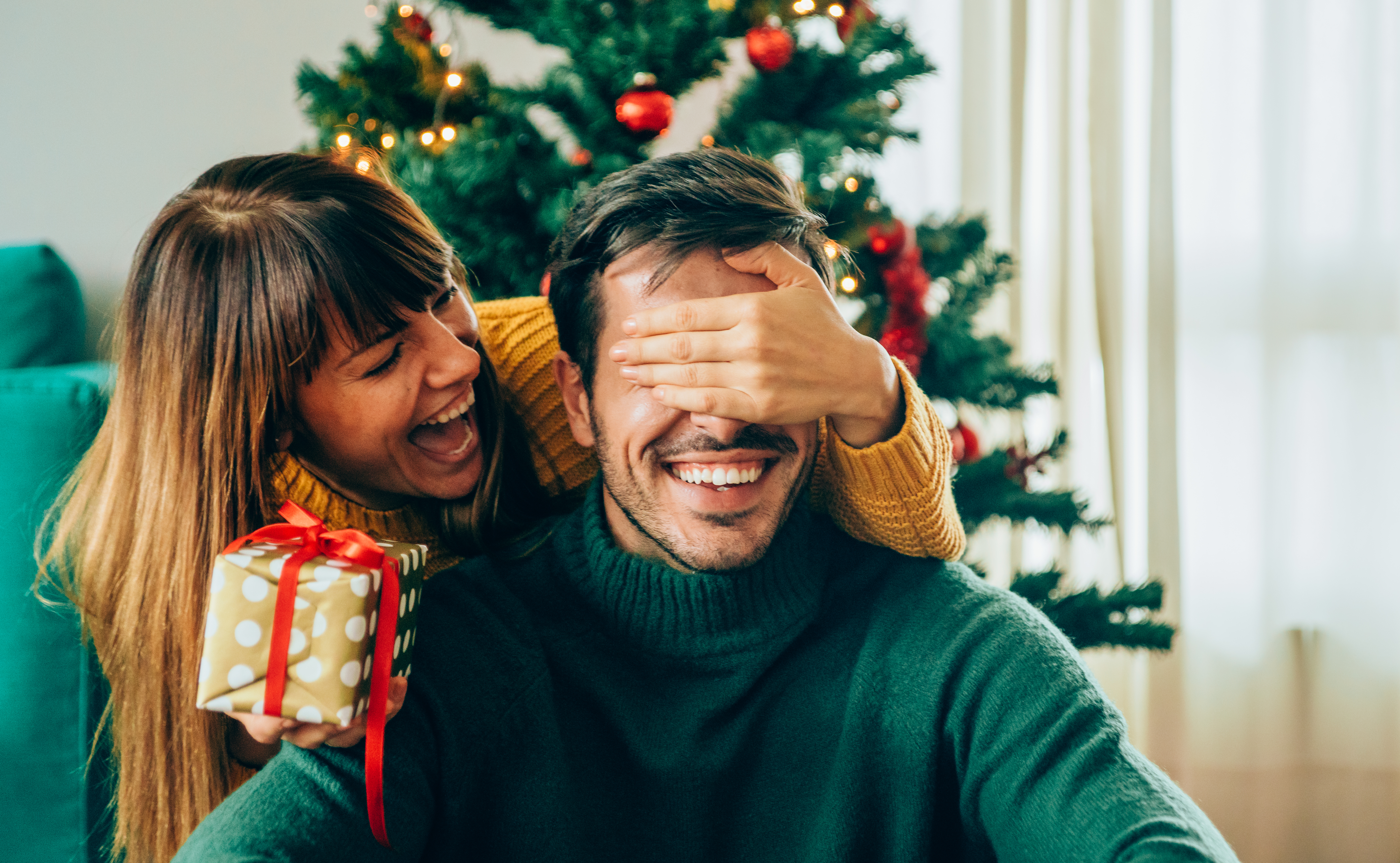 Pareja de jóvenes intercambiando regalos de Navidad | Fuente: Getty Images