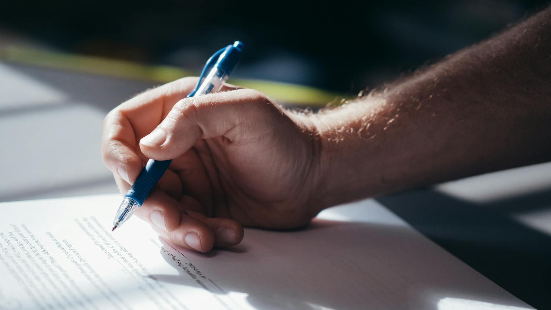 Un hombre firmando papeles | Fuente: Pexels