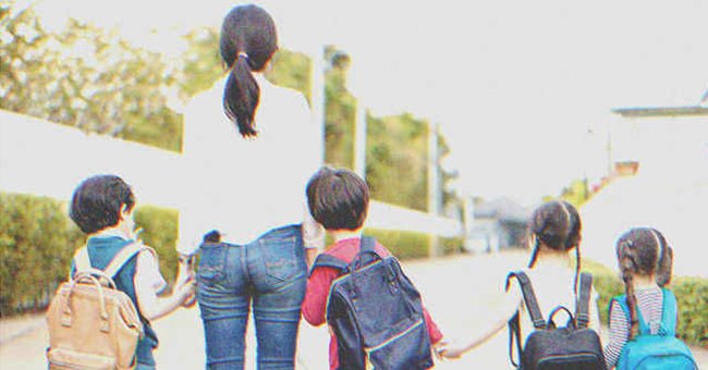 Una mujer caminando por la calle con cuatro niños. | Foto: Shutterstock