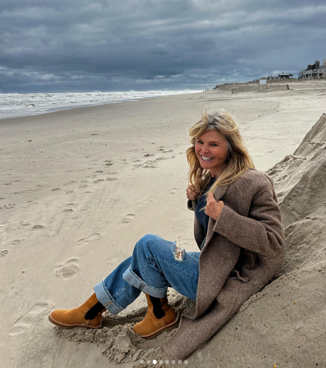 Sentada en la arena, con un abrigo marrón y unos jeans con los bajos remangados, Brinkley luce su pelo al viento con un cielo nublado de fondo. Comparó sus primeras canas con las olas del mar y dijo que quizá esperaría hasta que su pelo se pareciera a las crestas plateadas de las olas antes de aceptar el cambio. | Fuente: Instagram/christiebrinkley