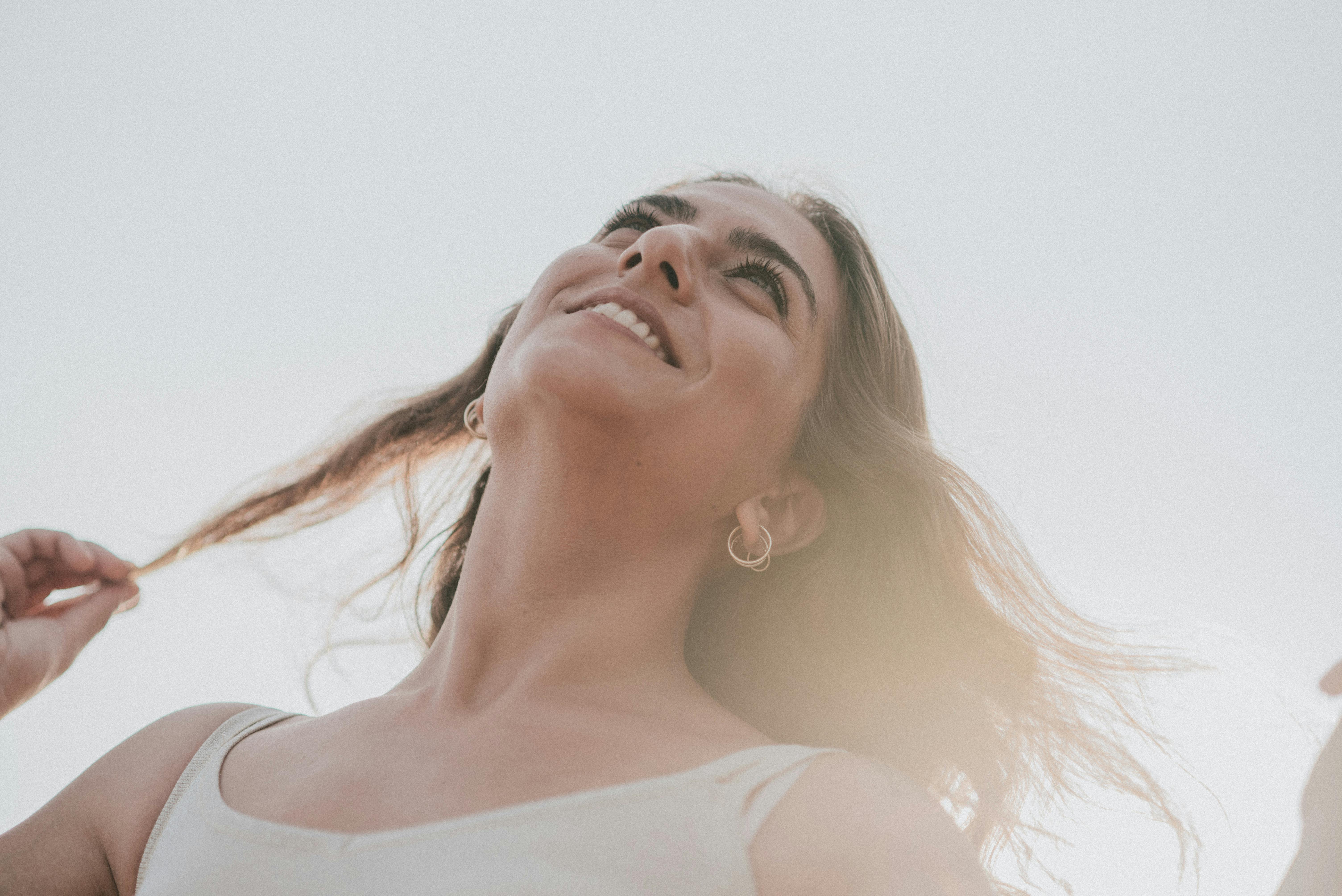 Una mujer feliz al aire libre | Fuente: Pexels