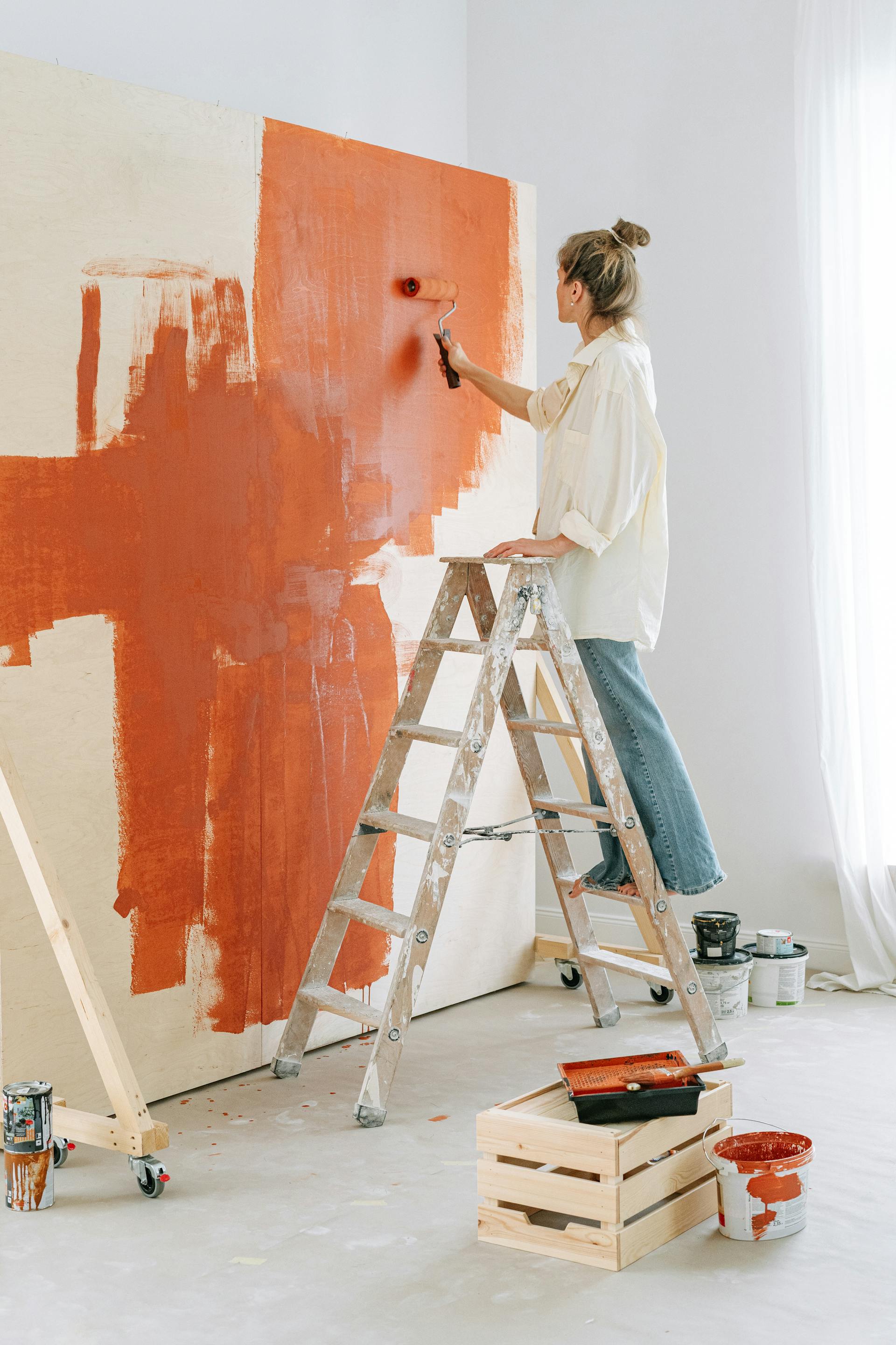 Una mujer pintando una pared | Fuente: Pexels