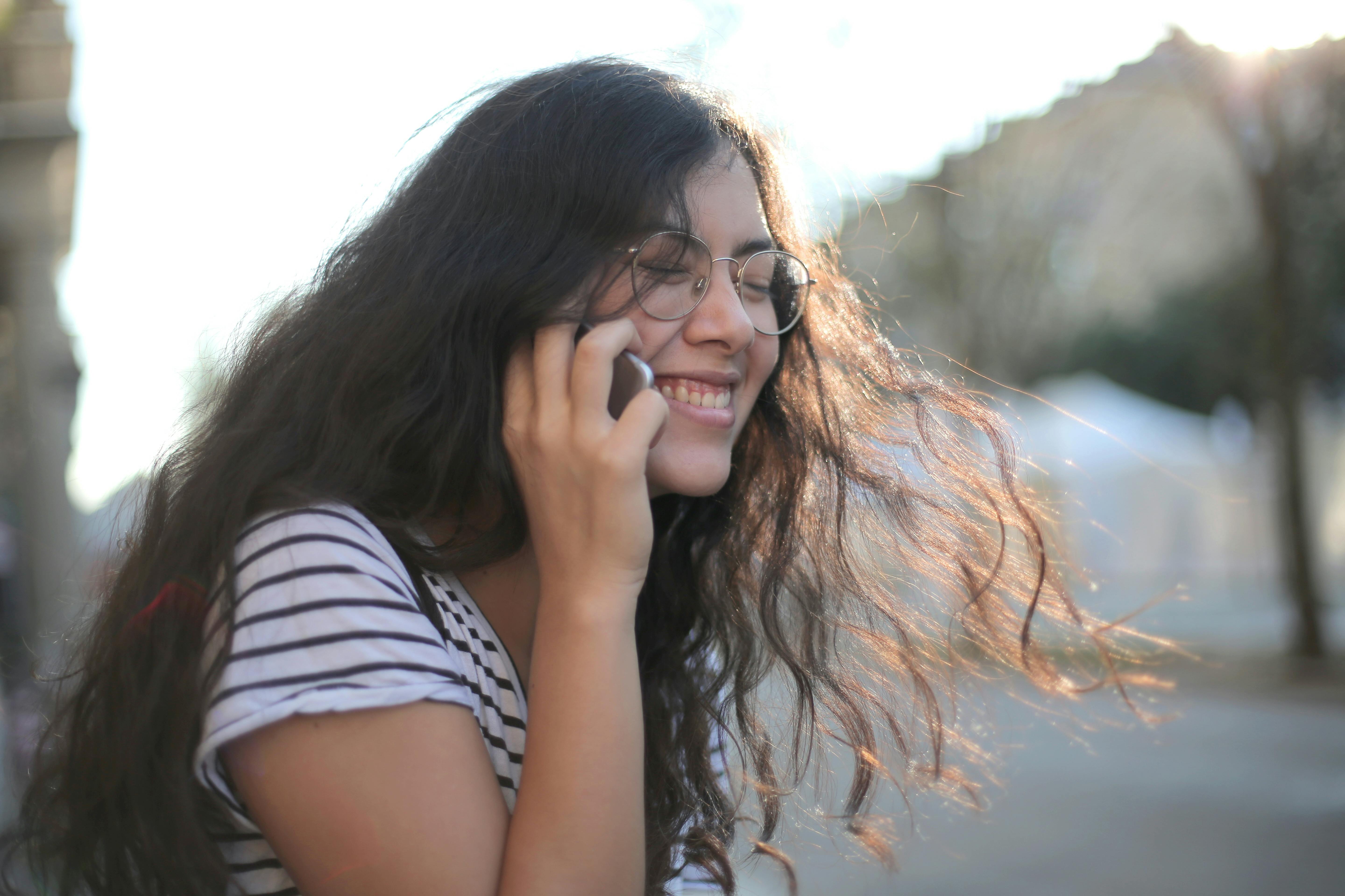 Una ragazza che ride mentre è al telefono | Fonte: Pexels
