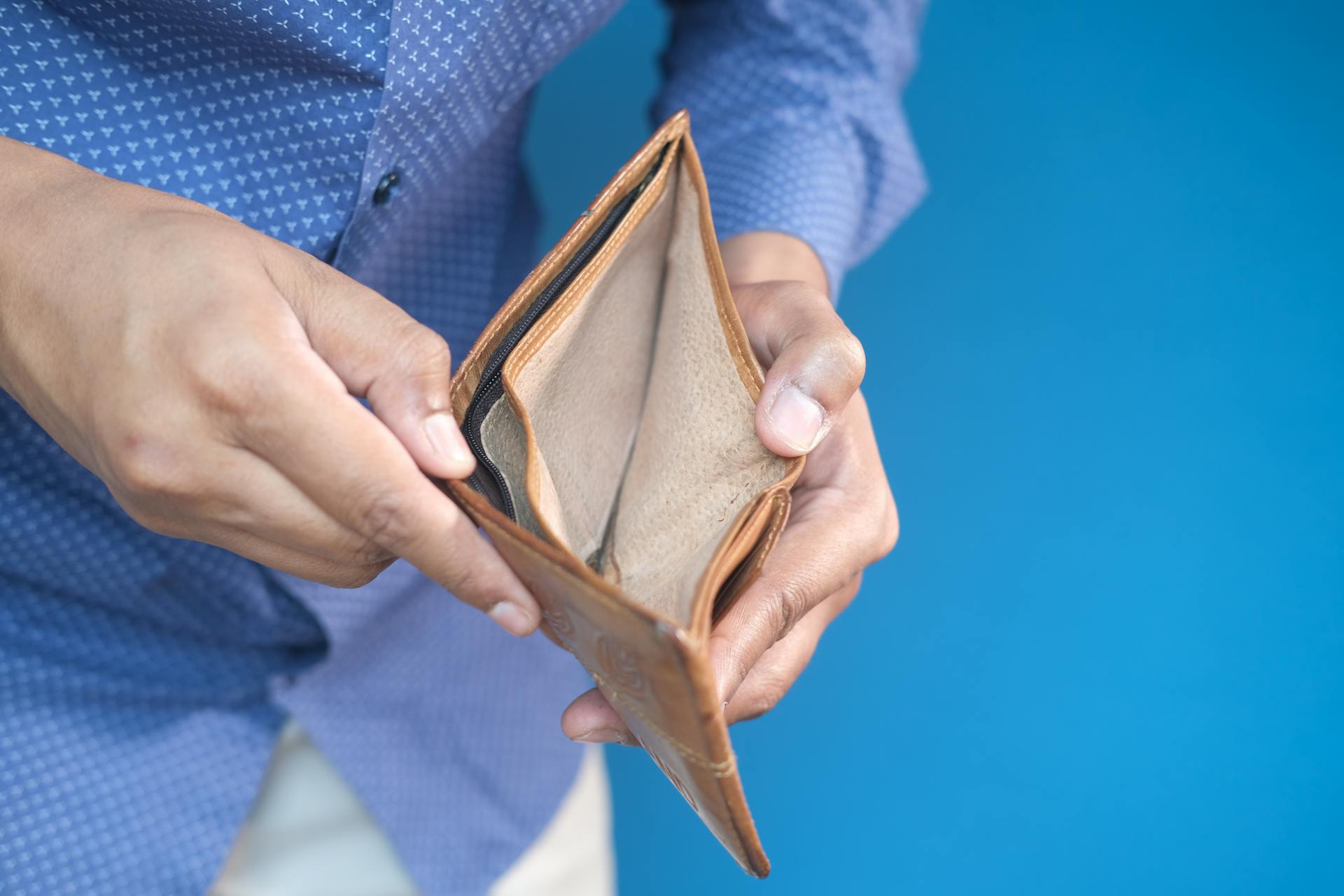 Hombre con una cartera vacía | Fuente: Pexels