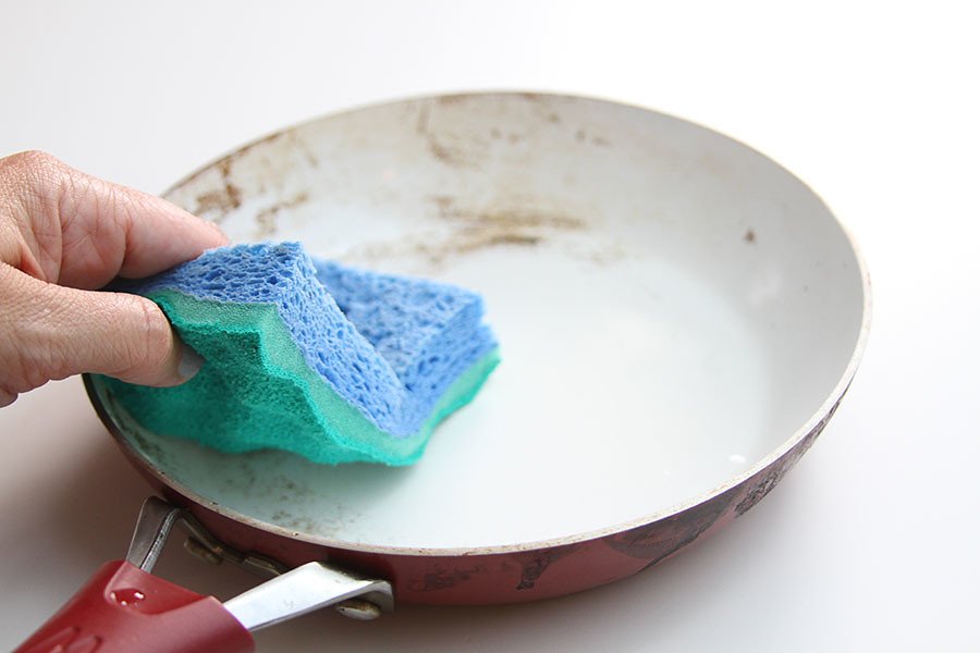 Persona lavando un sartén con esponja. | Foto: Flickr