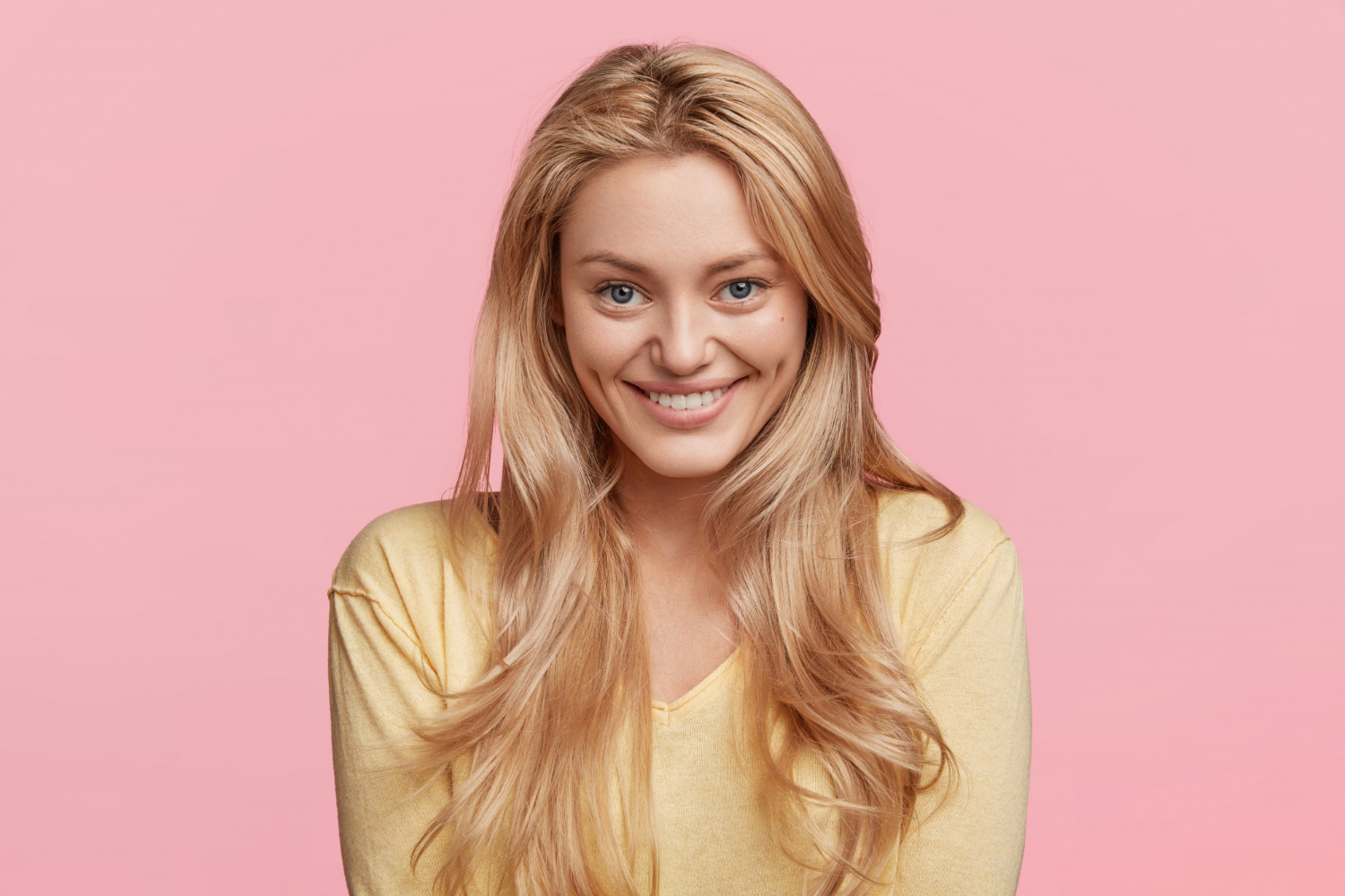 Una mujer sonriendo encantada | Fuente: Freepik