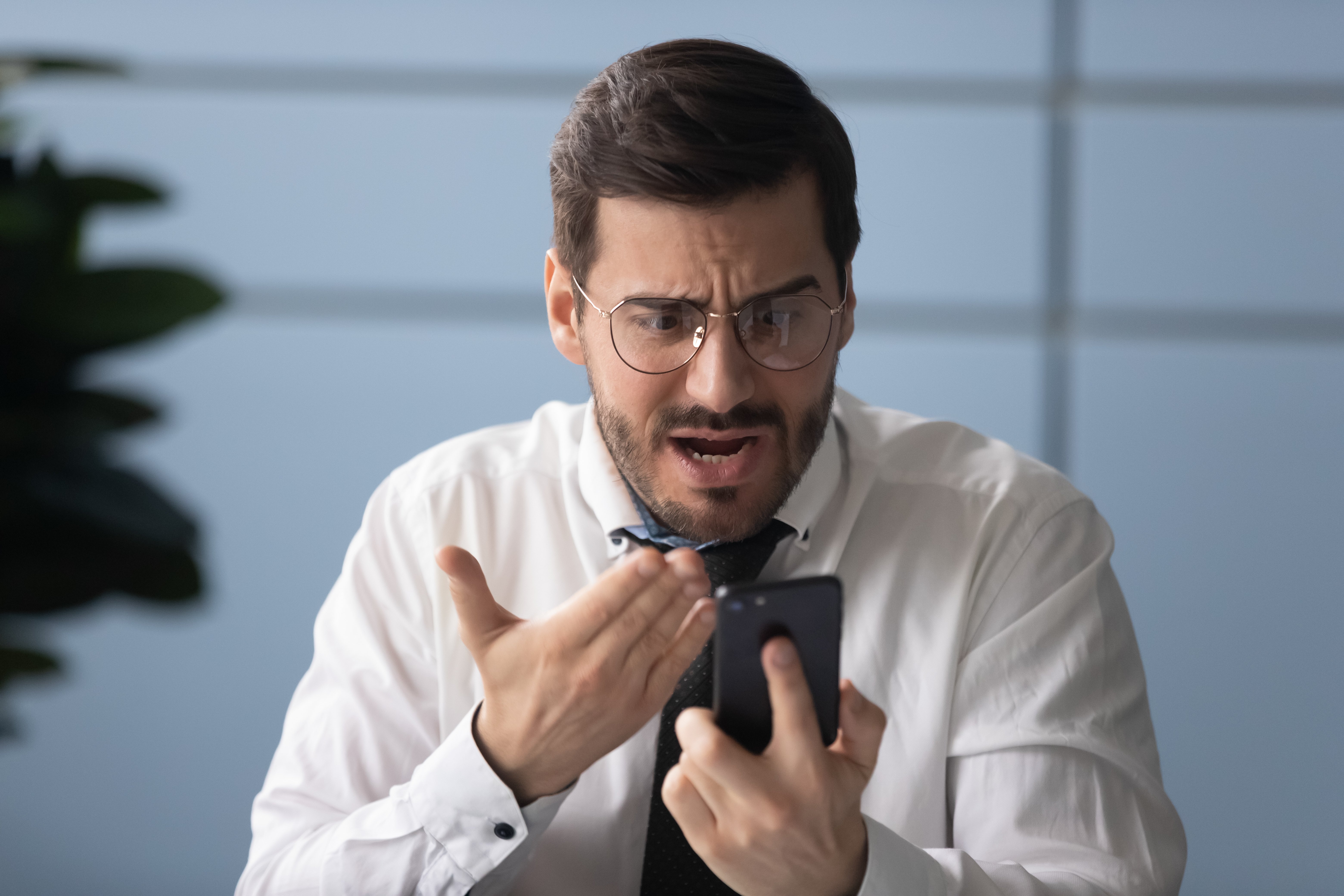 Hombre confundido viendo su teléfono. | Foto: Shutterstock