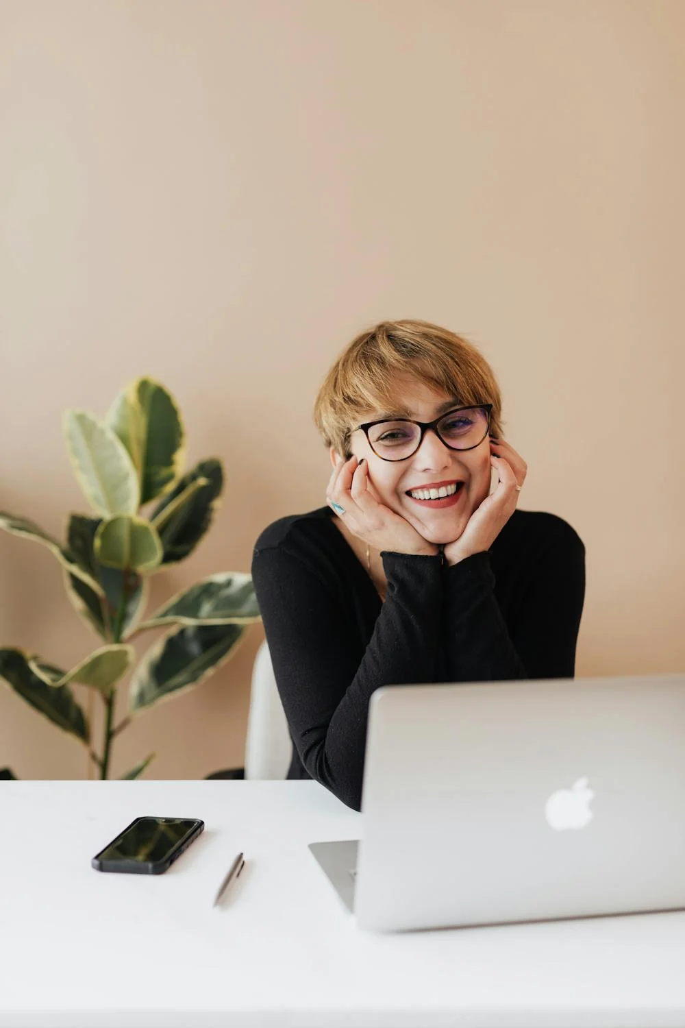 Una mujer sonriente en su despacho | Fuente: Pexels