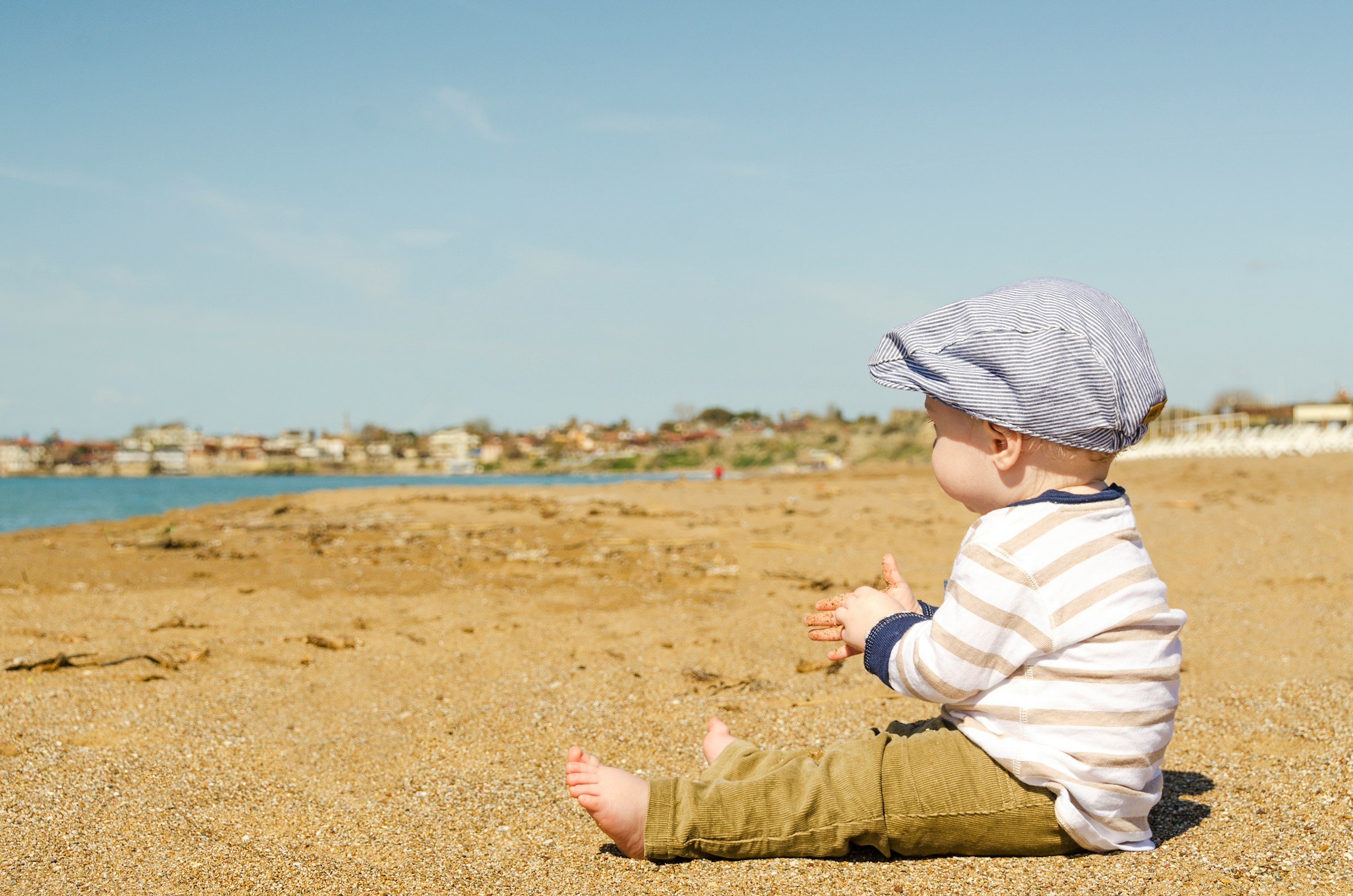 Un bebé sentado en la playa | Foto: Pexels