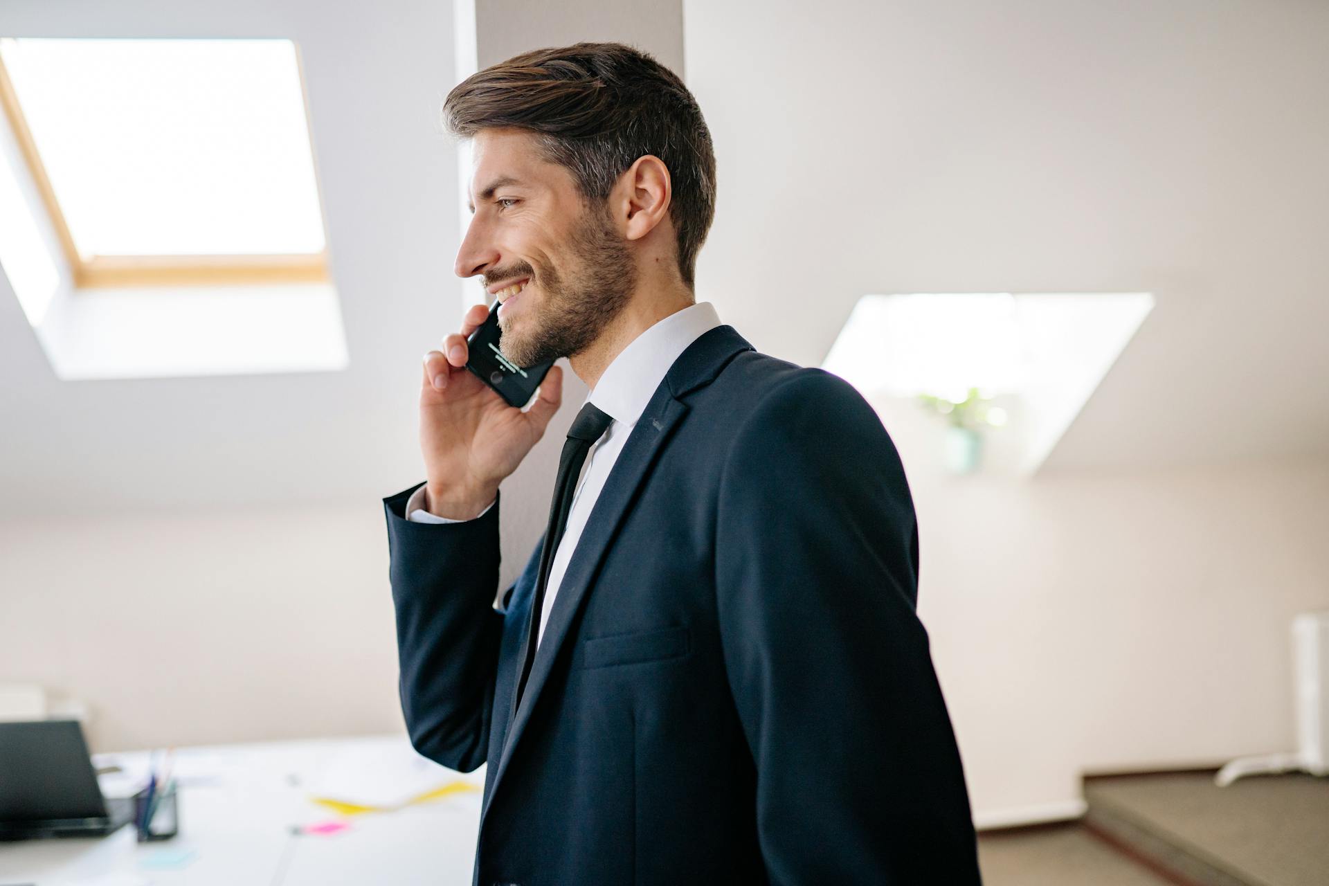 Un hombre sonriendo durante una llamada telefónica | Fuente: Pexels