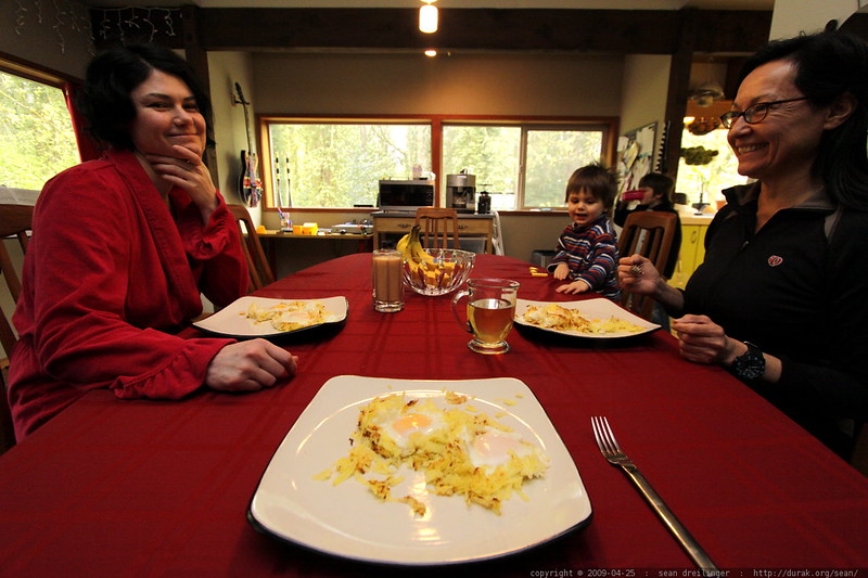 Una foto de dos mujeres sonriéndose mientras están sentadas al otro lado de la mesa con un niño pequeño. | Foto: Flickr